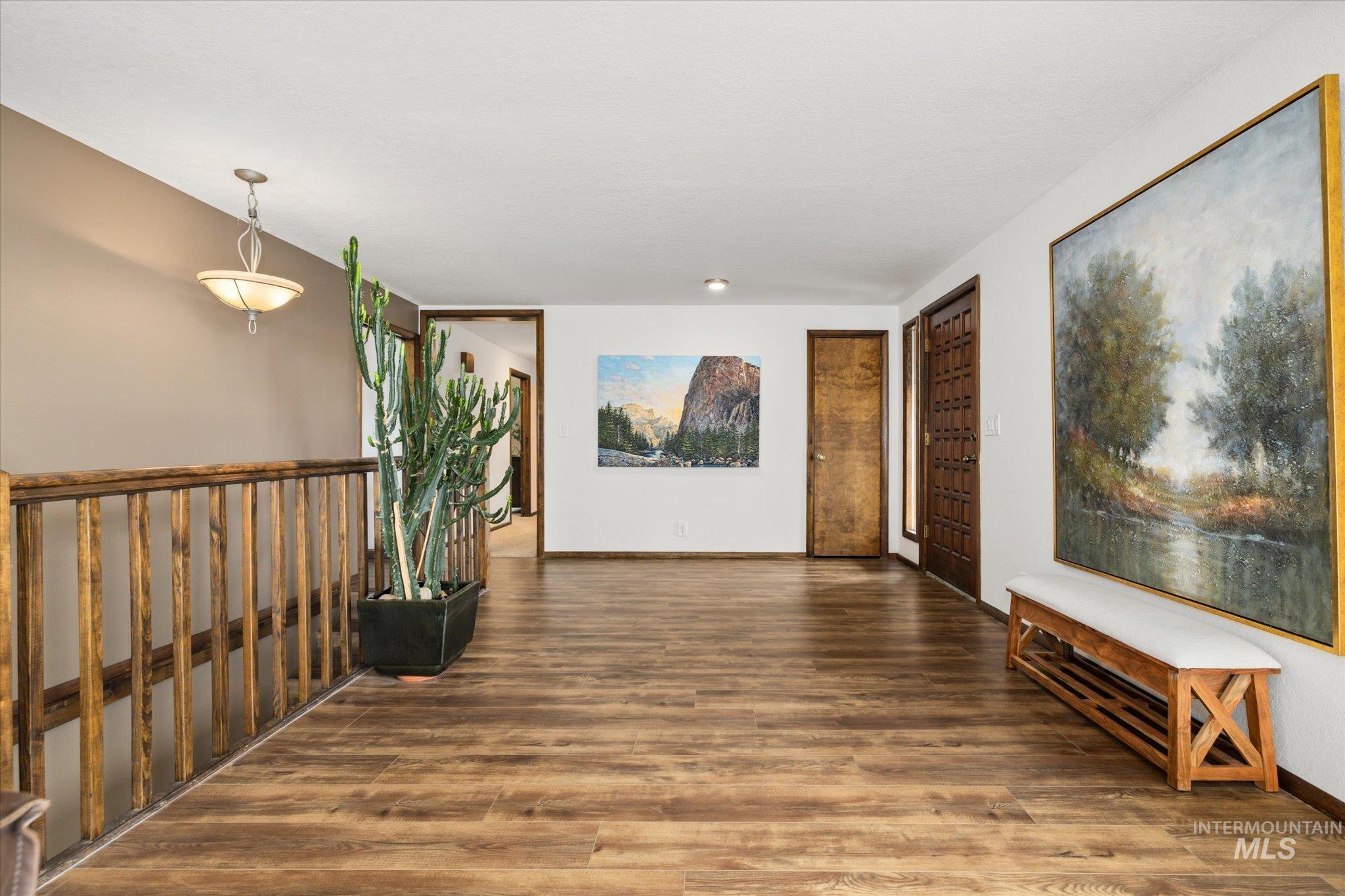 Corridor with dark wood-type flooring and baseboards