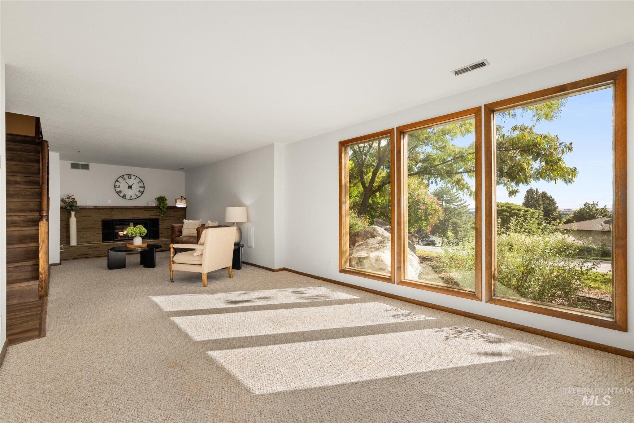 Unfurnished room featuring a lit fireplace and carpet