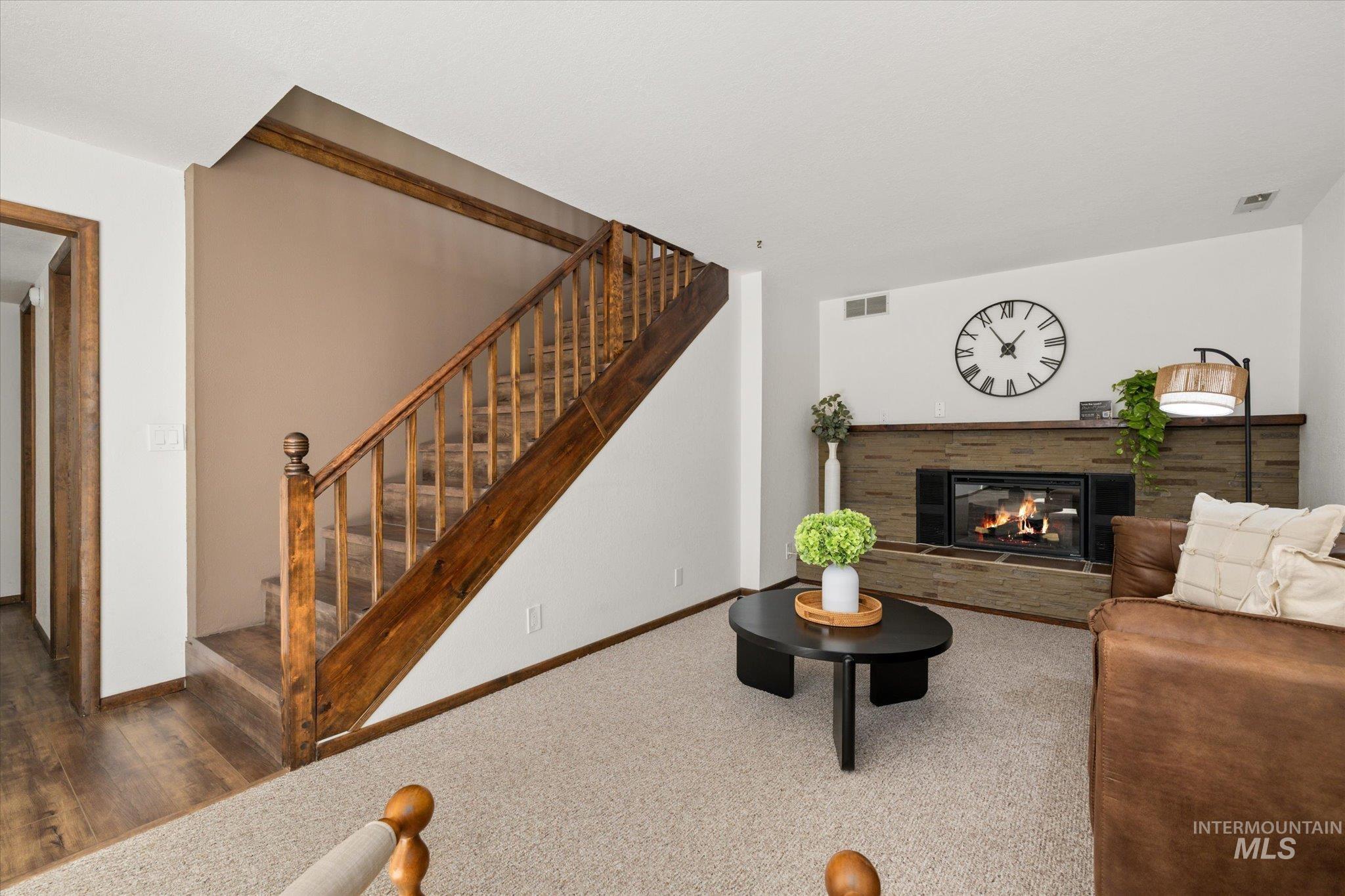 Carpeted living room featuring a multi sided fireplace and stairs