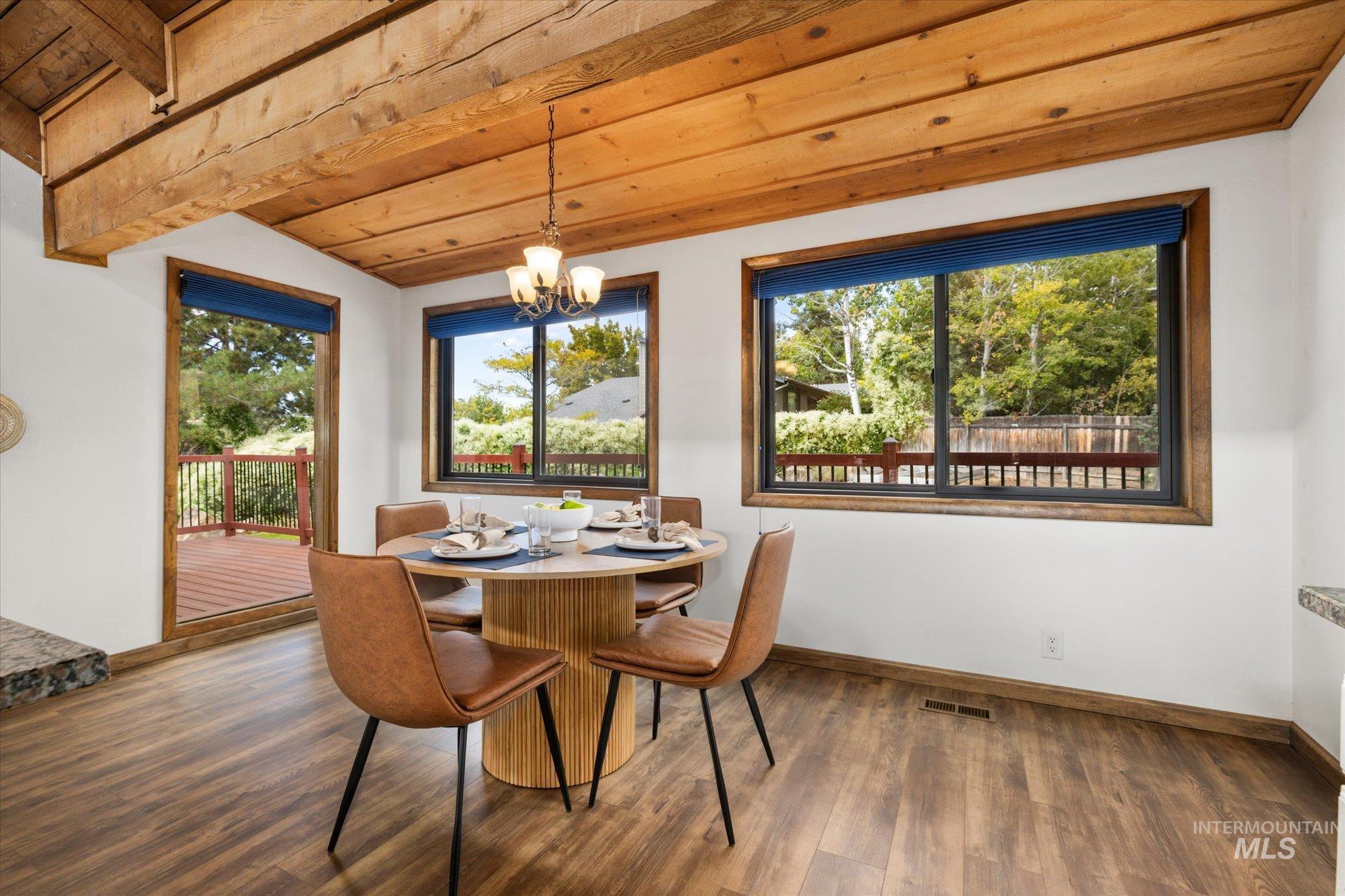 Dining space with wood ceiling, a chandelier, and wood finished floors