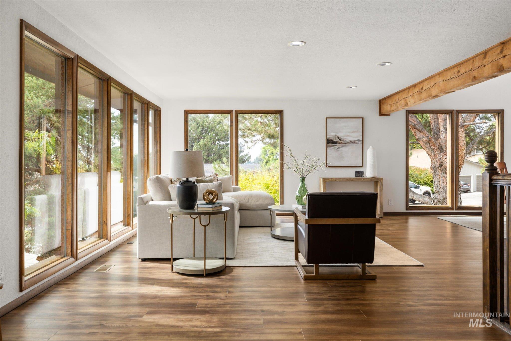 Living area featuring wood finished floors, beam ceiling, and recessed lighting