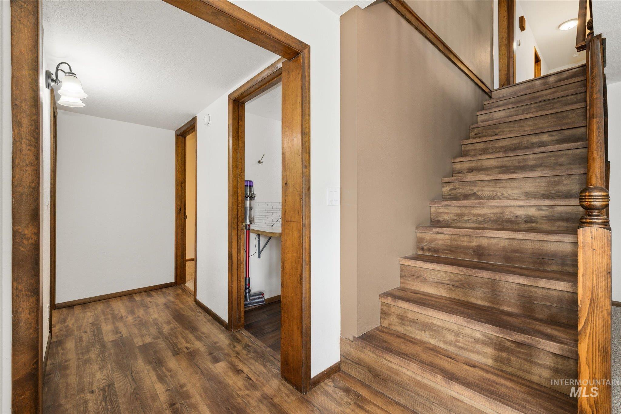 Staircase featuring wood finished floors and baseboards