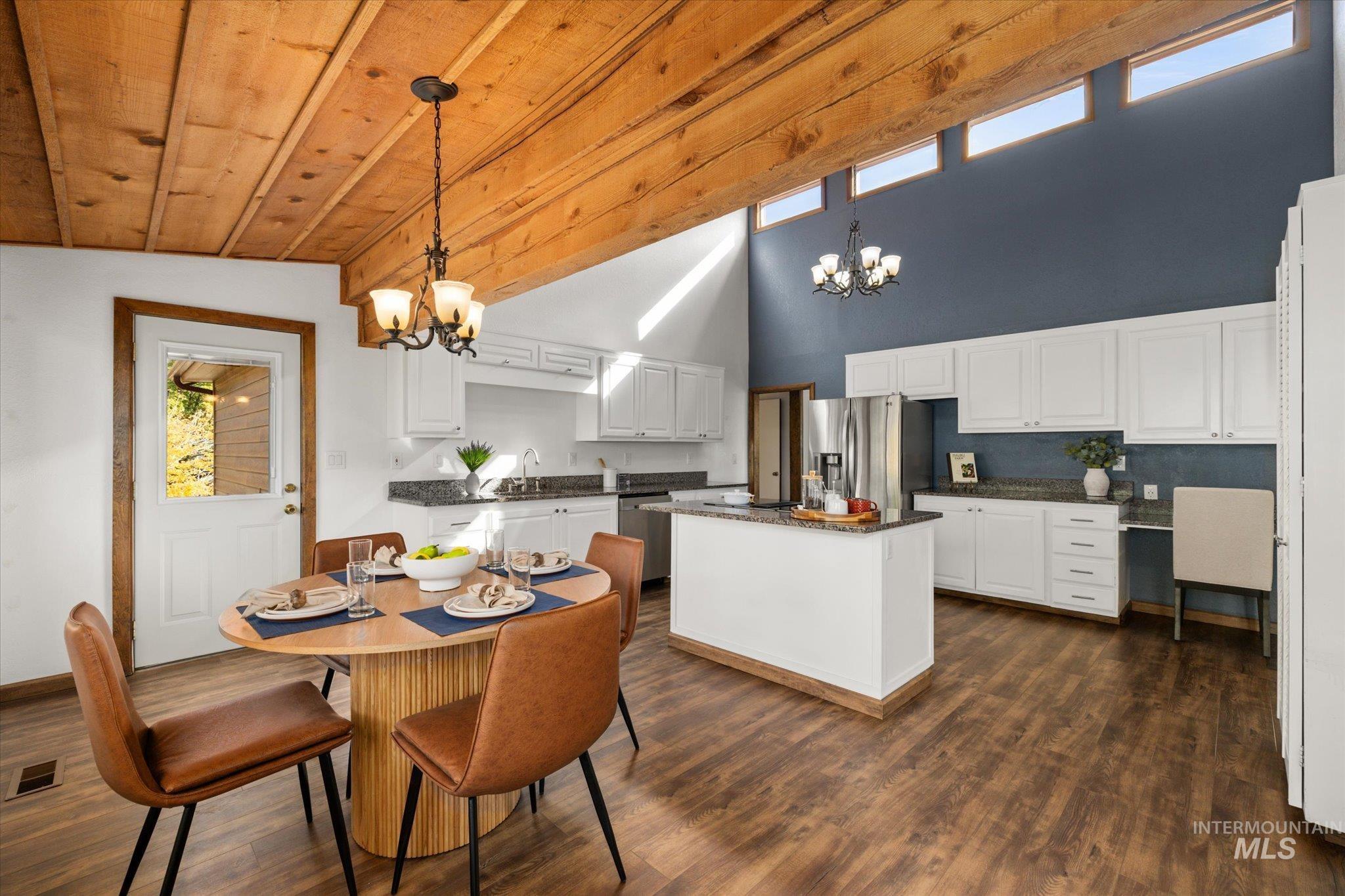 Dining space featuring a chandelier, a high ceiling, and dark wood-style flooring