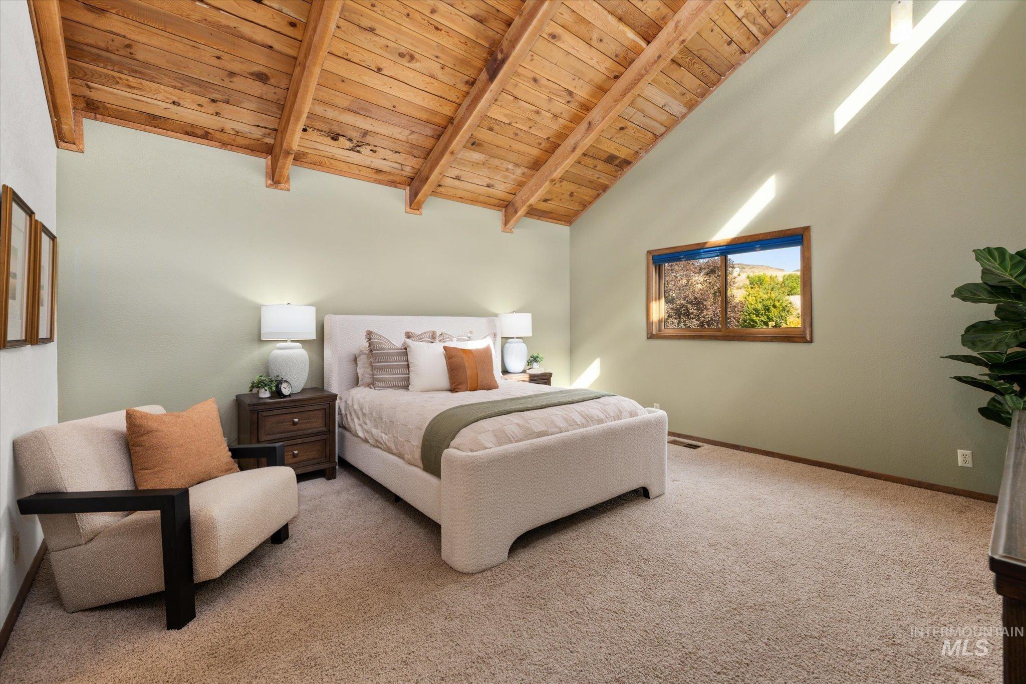 Bedroom featuring a wood ceiling with exposed beams, light colored carpet, and high vaulted ceiling