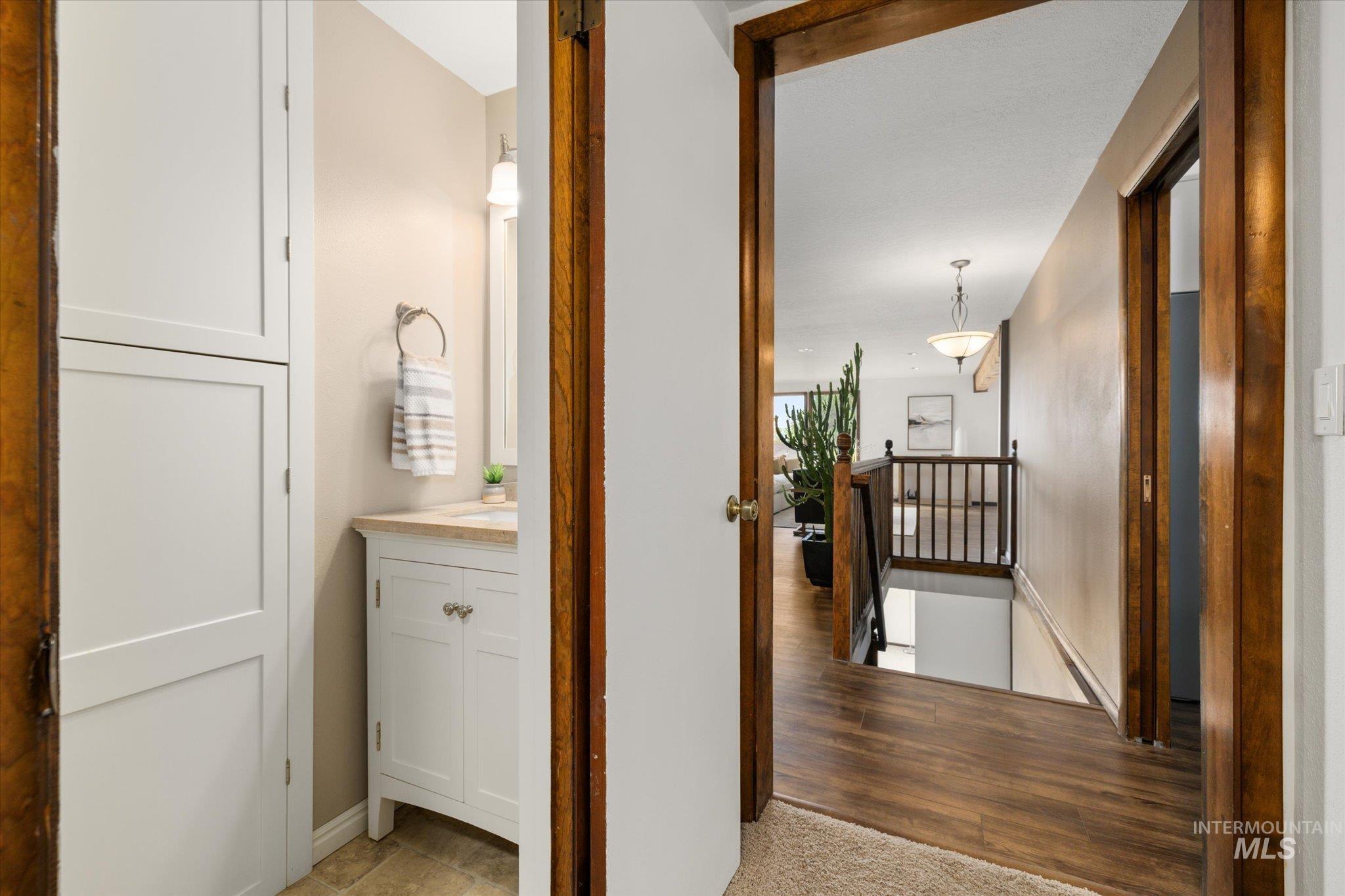Corridor with an upstairs landing and light wood-style flooring