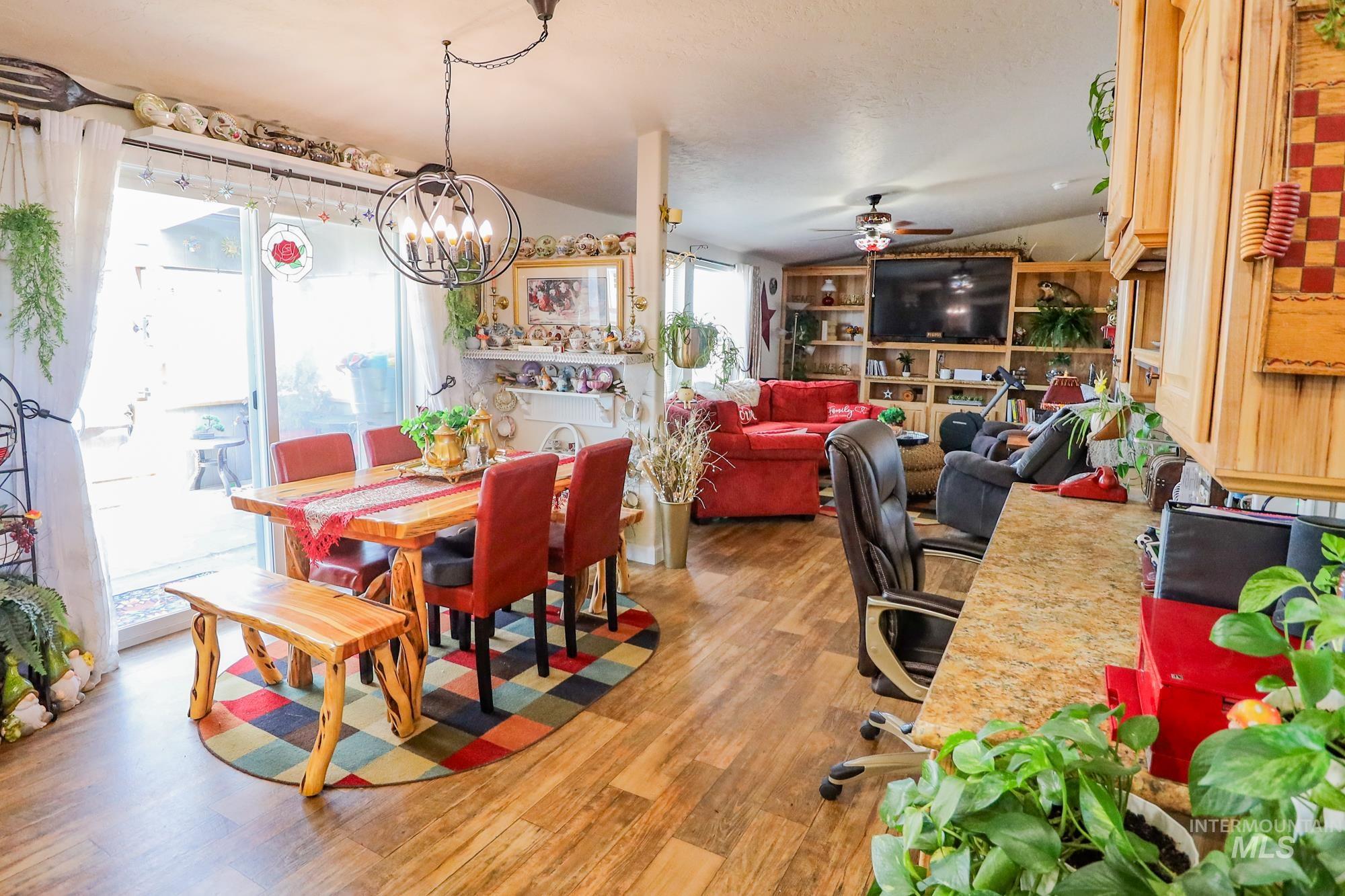 Dining space featuring ceiling fan, a chandelier, and light wood-style floors