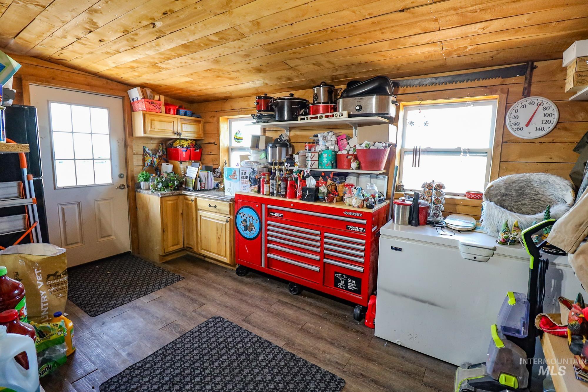 Misc room with wooden ceiling, dark wood-style floors, and wooden walls