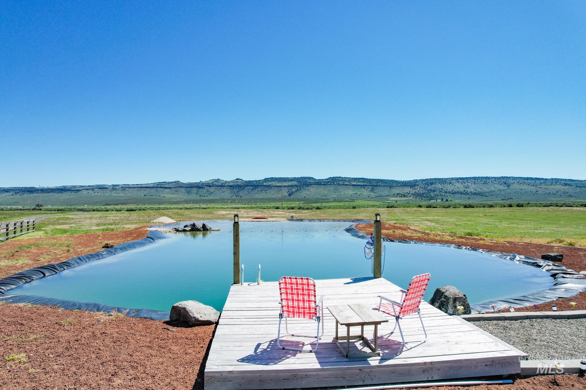 Dock featuring a water and mountain view and a view of rural / pastoral area