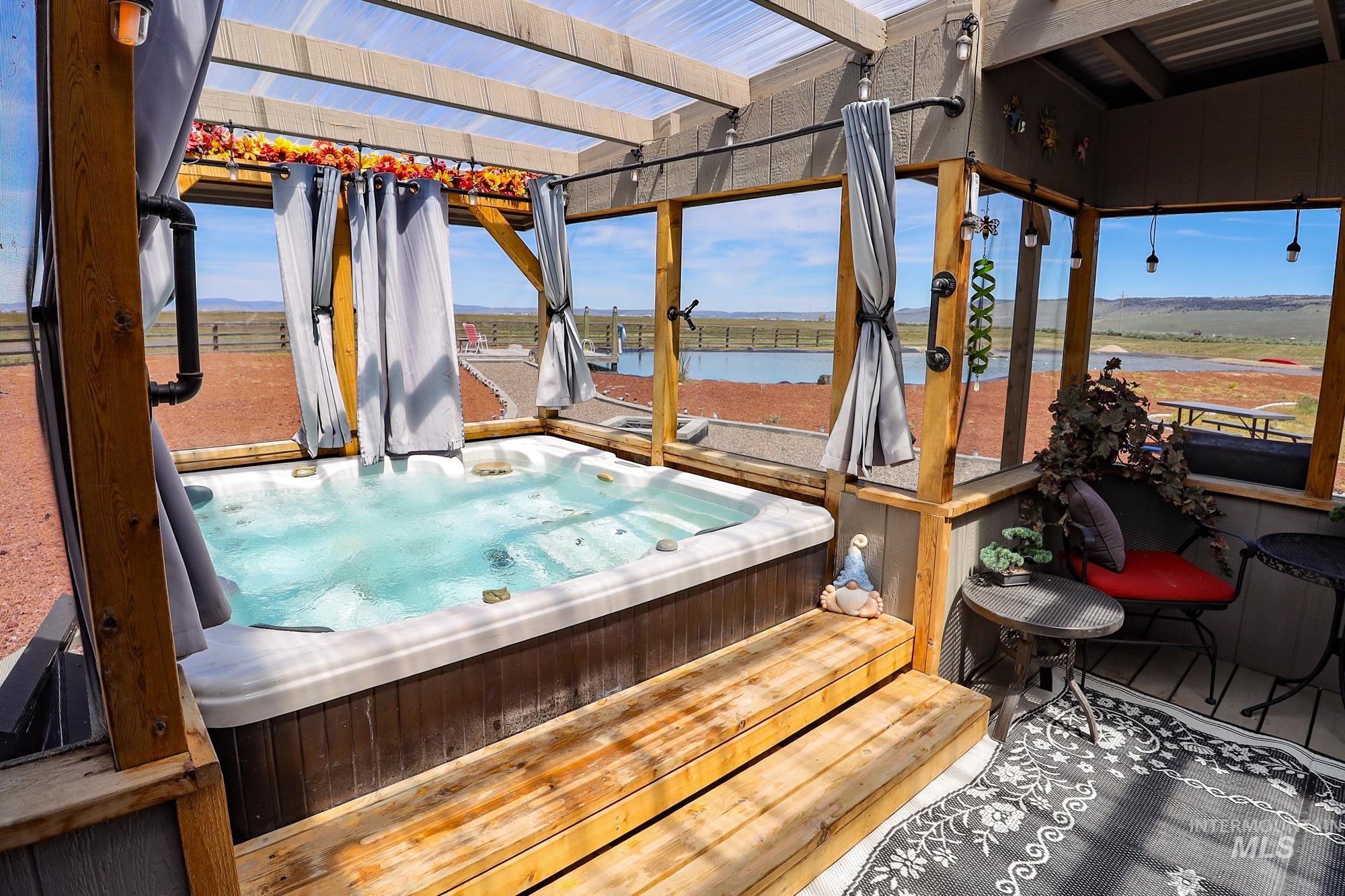 Wooden deck with a hot tub and a water view
