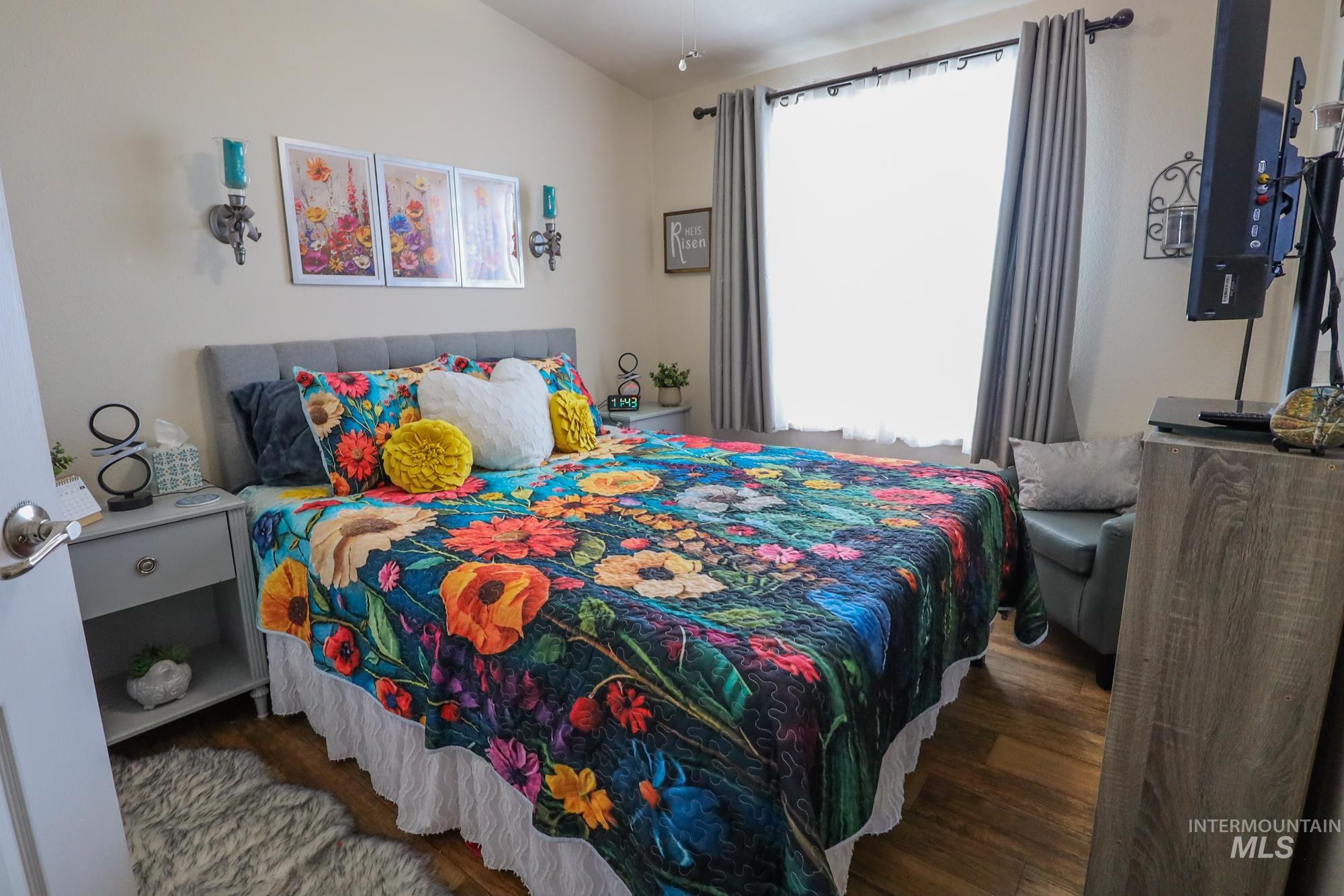 Bedroom featuring multiple windows and wood finished floors