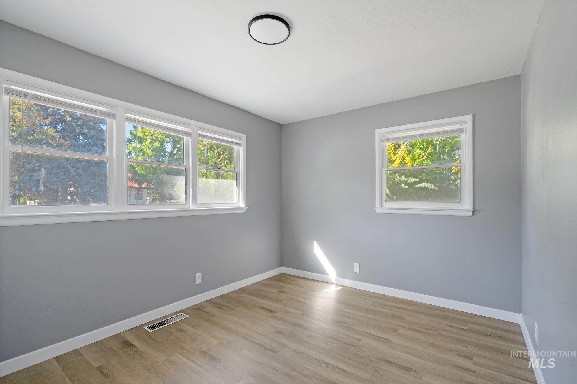 Unfurnished room with baseboards and light wood-type flooring