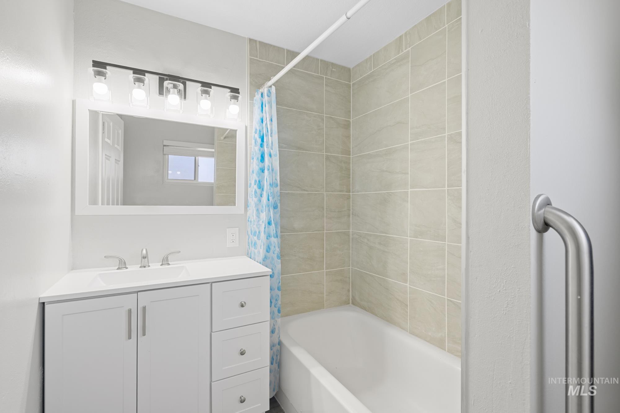 Bathroom featuring vanity and shower / bath combo with shower curtain
