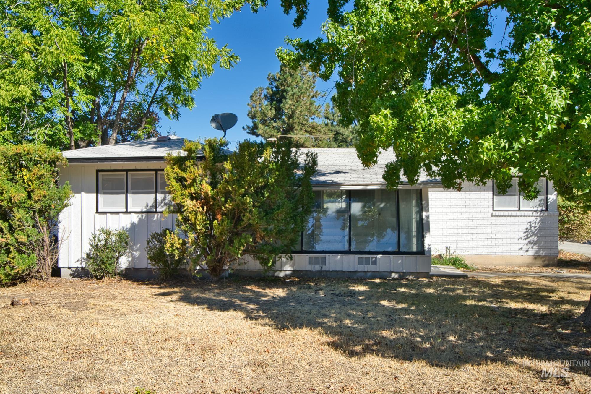 Back of house featuring a sunroom, brick siding, and a lawn