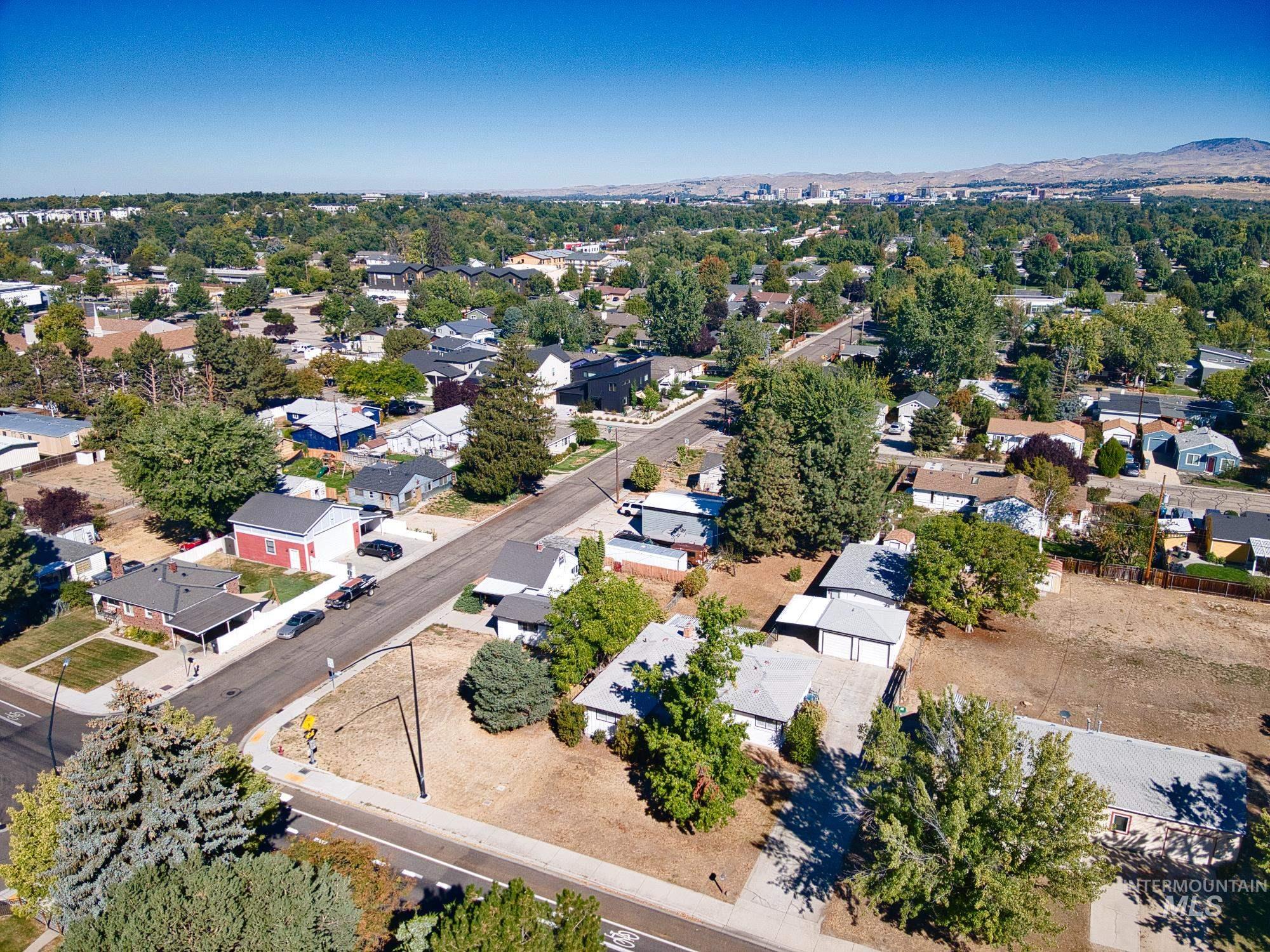Aerial view of property and surrounding area featuring nearby suburban area