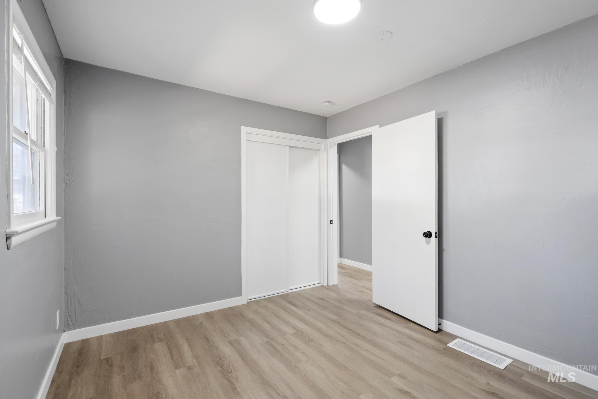 Unfurnished bedroom featuring light wood-type flooring and a closet
