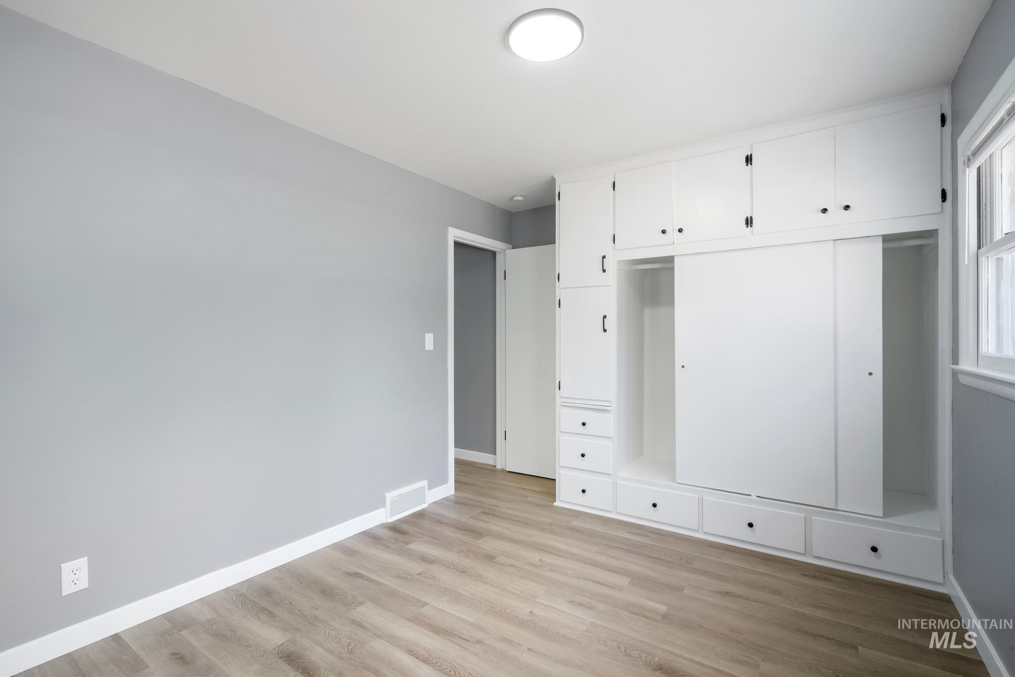 Unfurnished bedroom with light wood-type flooring and a closet
