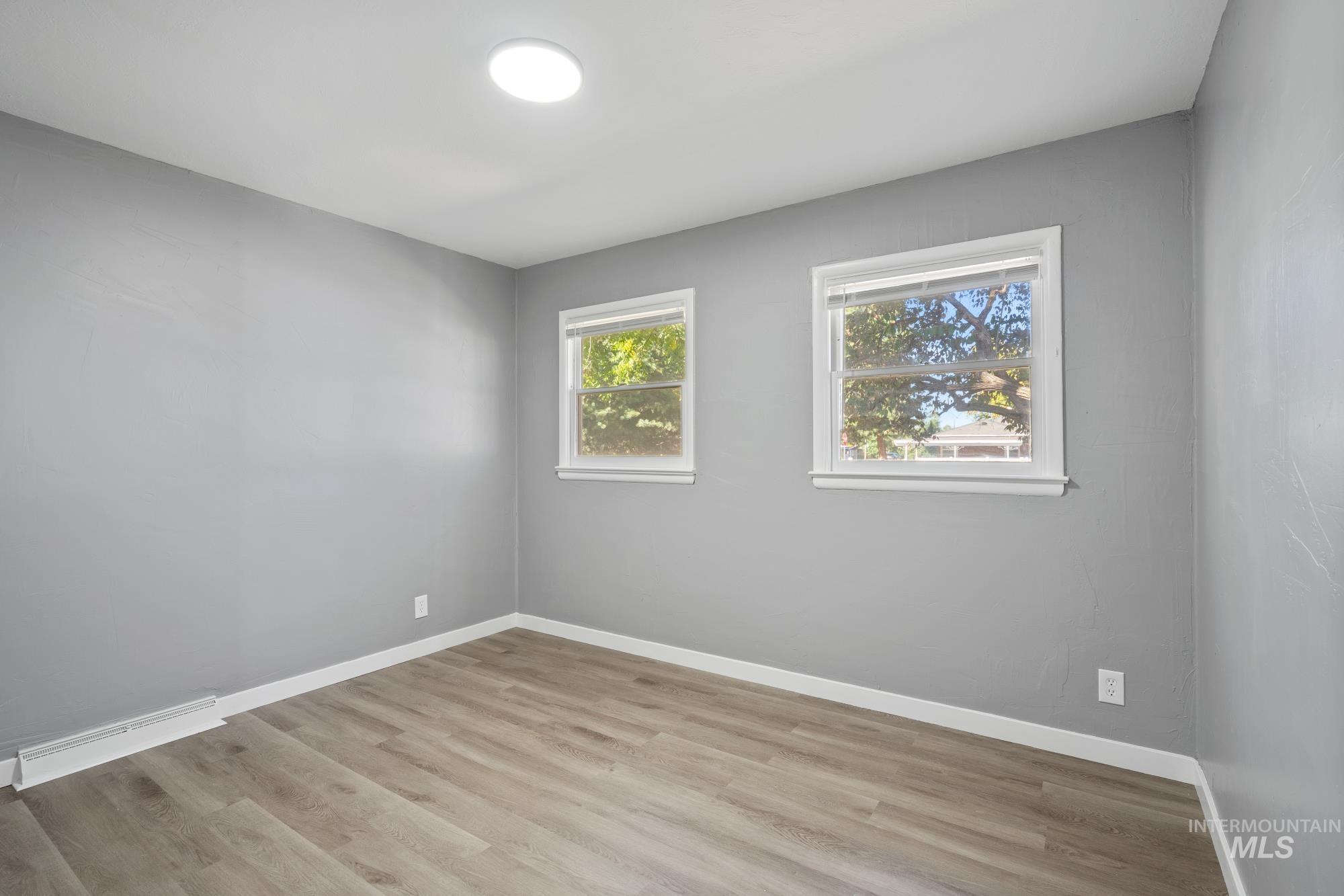 Spare room with baseboards and light wood-style flooring