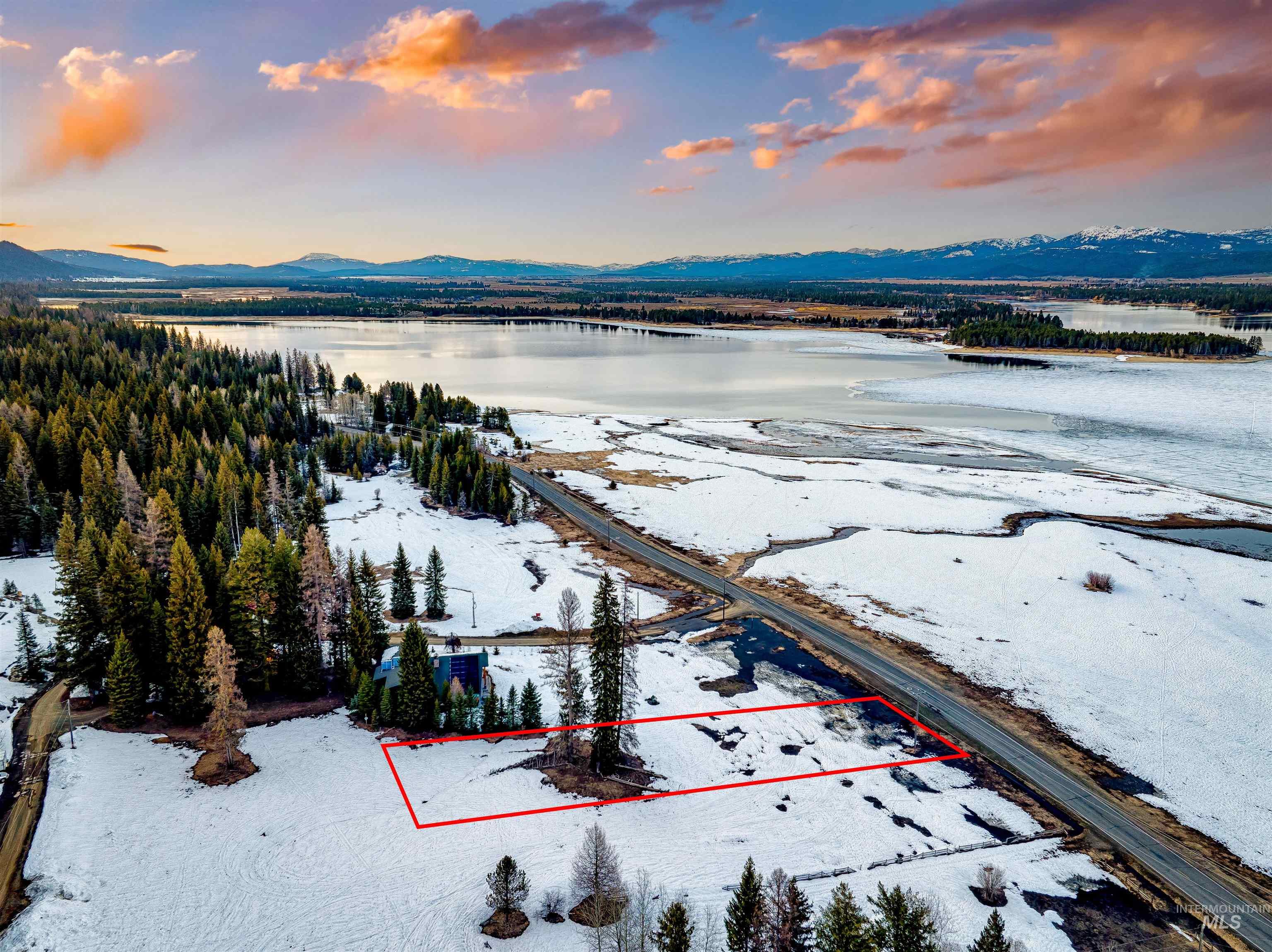 Aerial view of property and surrounding area with property parcel outlined and a water and mountain view