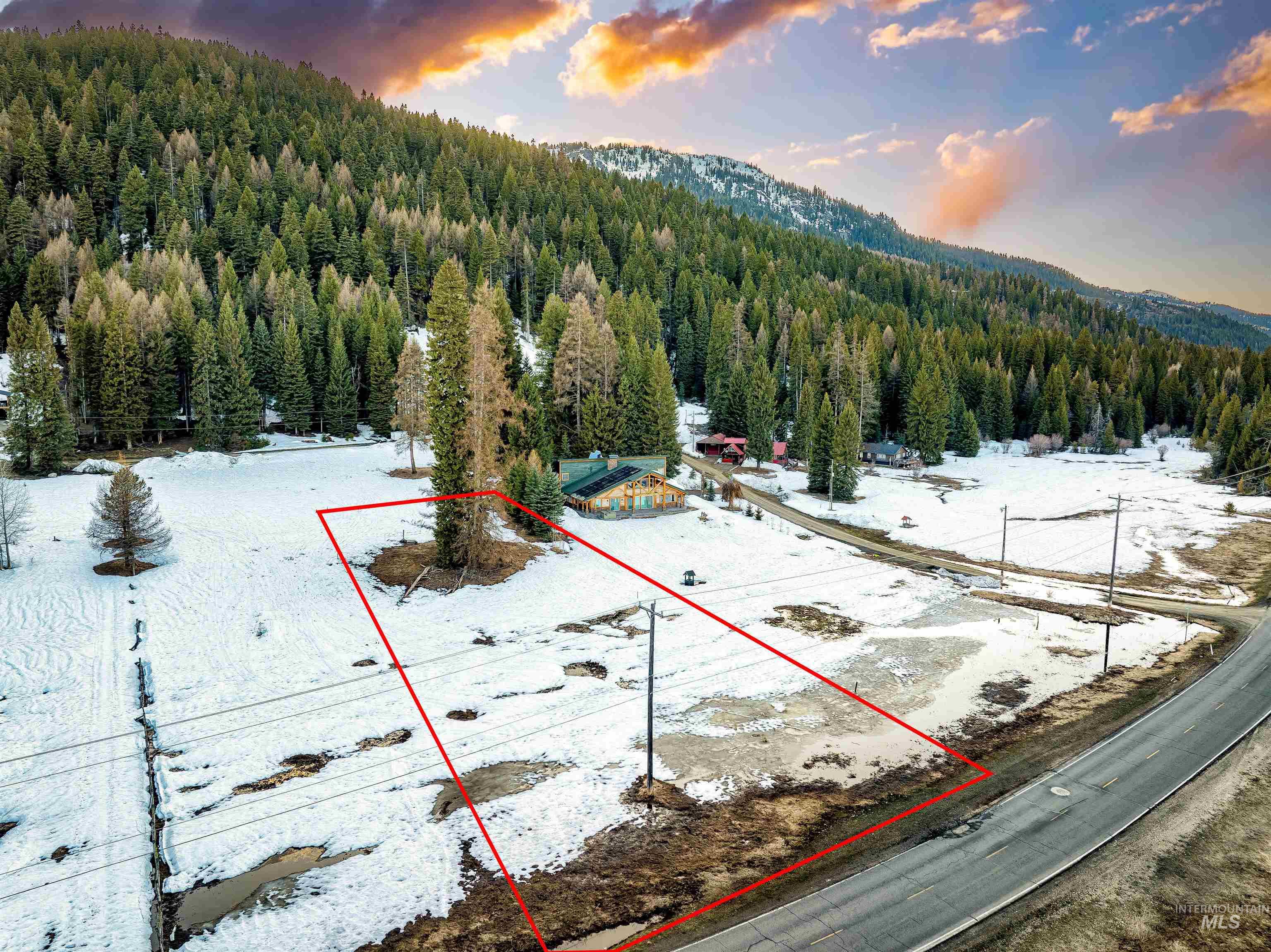 Aerial view at dusk of property boundaries highlighted, a view of trees, and a mountain view