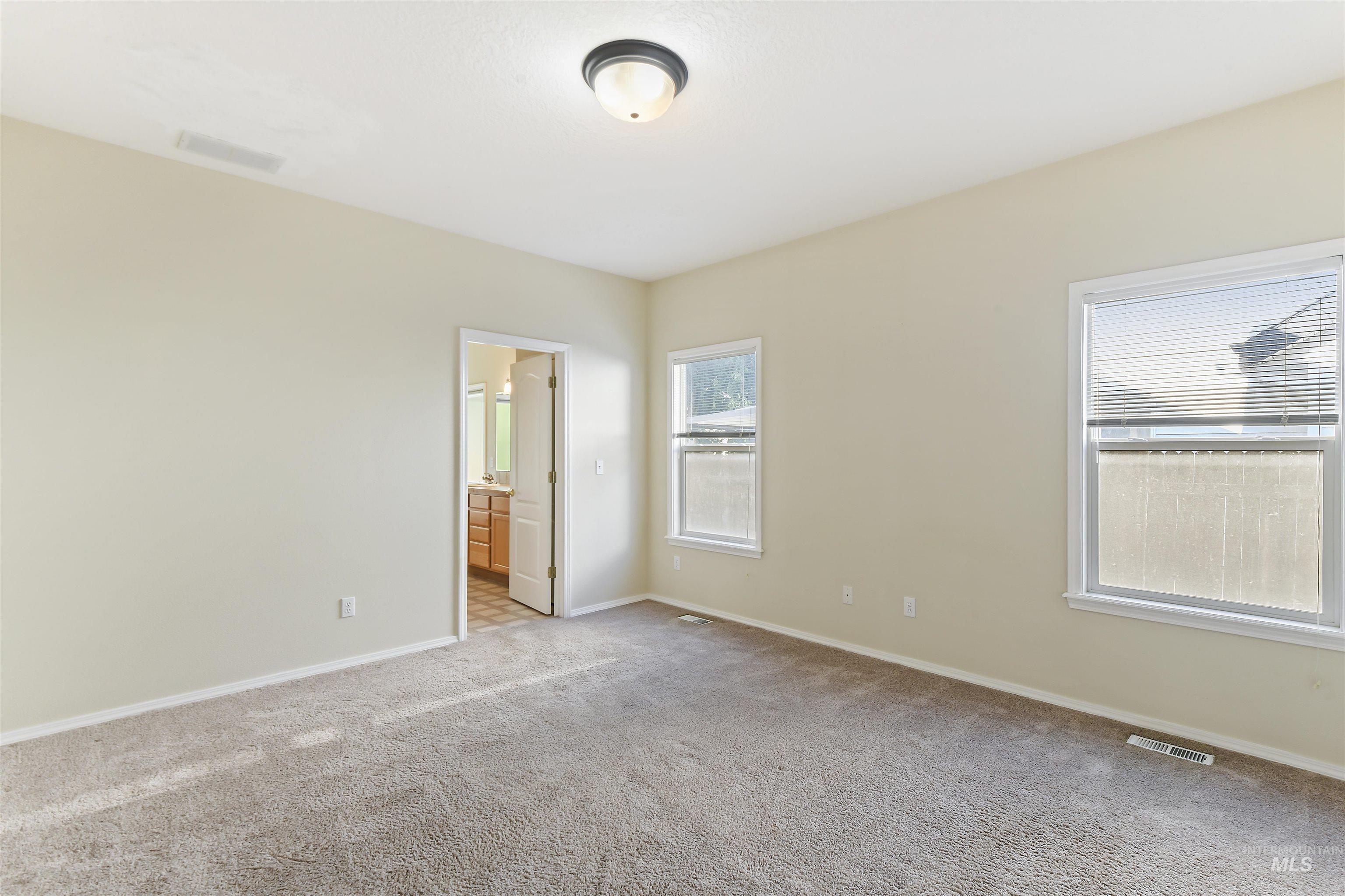Unfurnished bedroom with carpet and ensuite bath