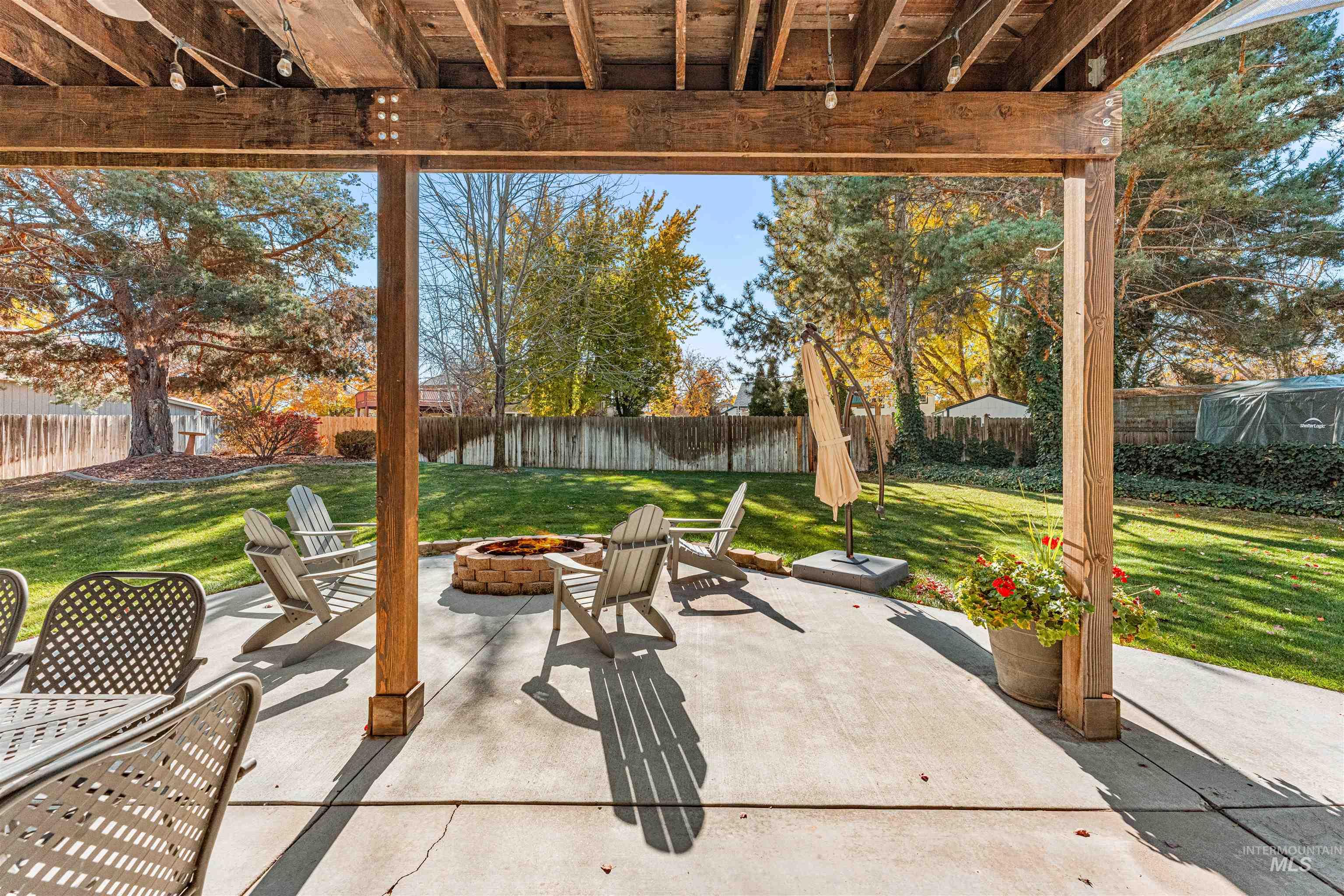 Fenced backyard featuring an outdoor fire pit and a patio