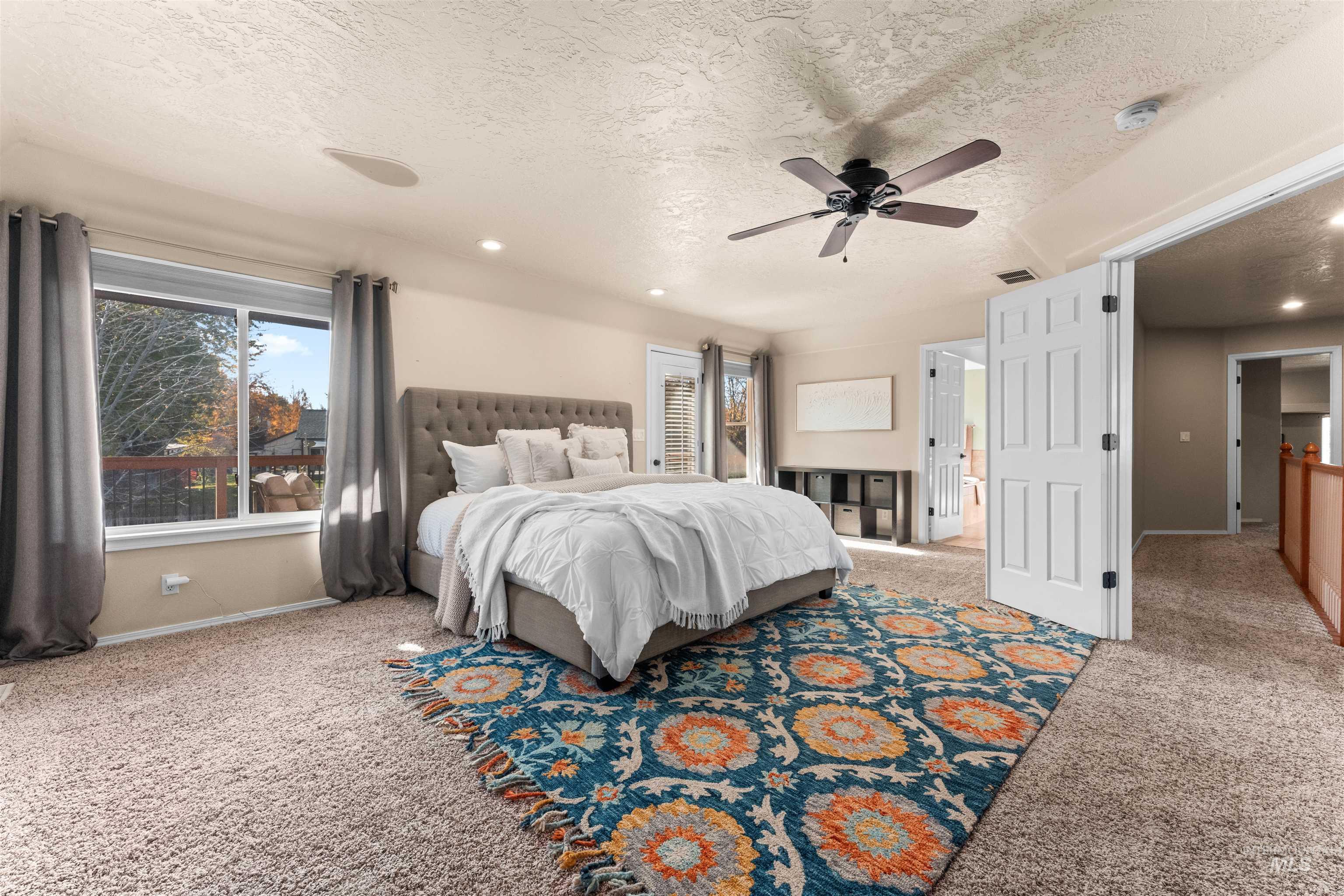Bedroom with light colored carpet, a textured ceiling, ceiling fan, and recessed lighting