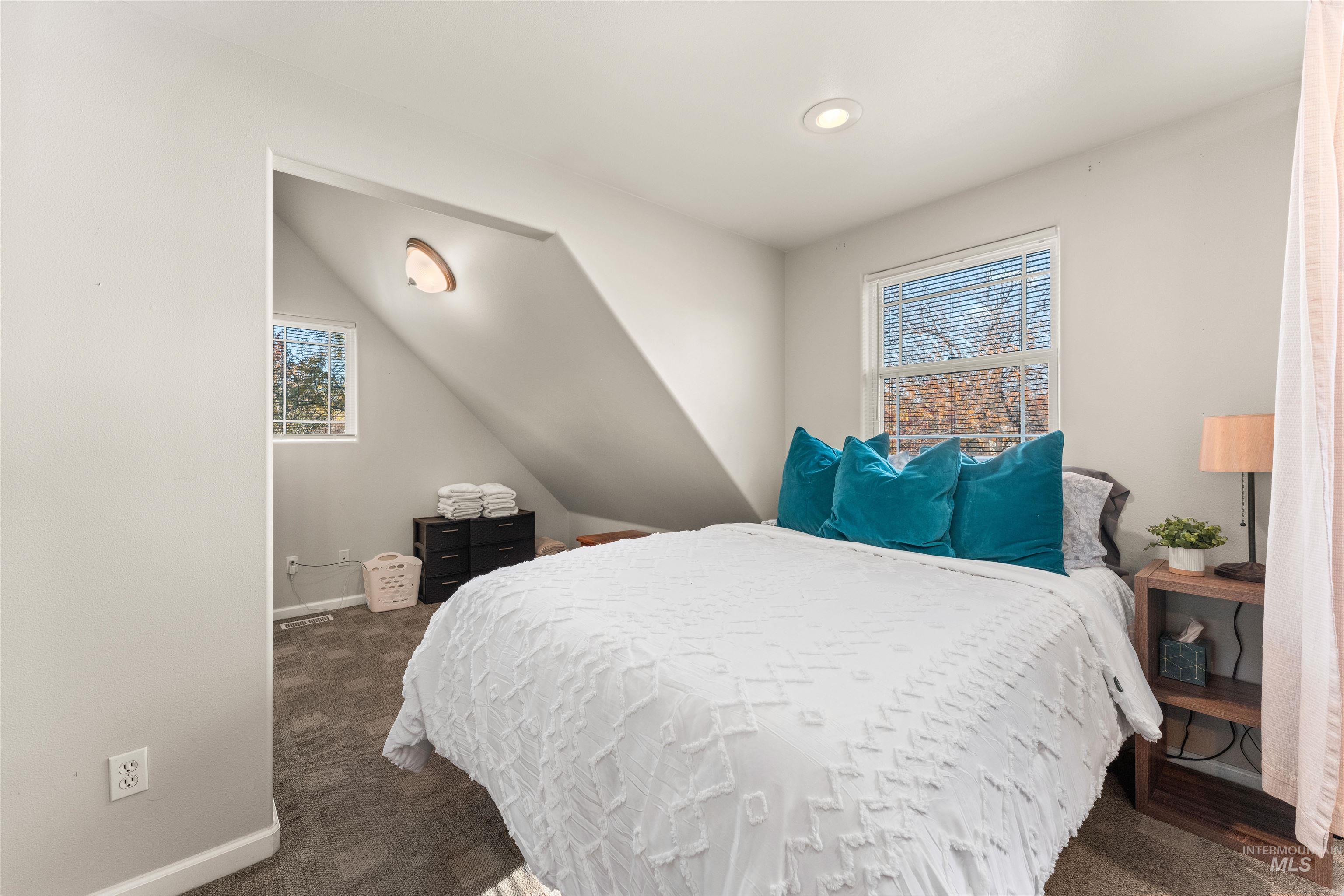 Bedroom featuring dark carpet and vaulted ceiling