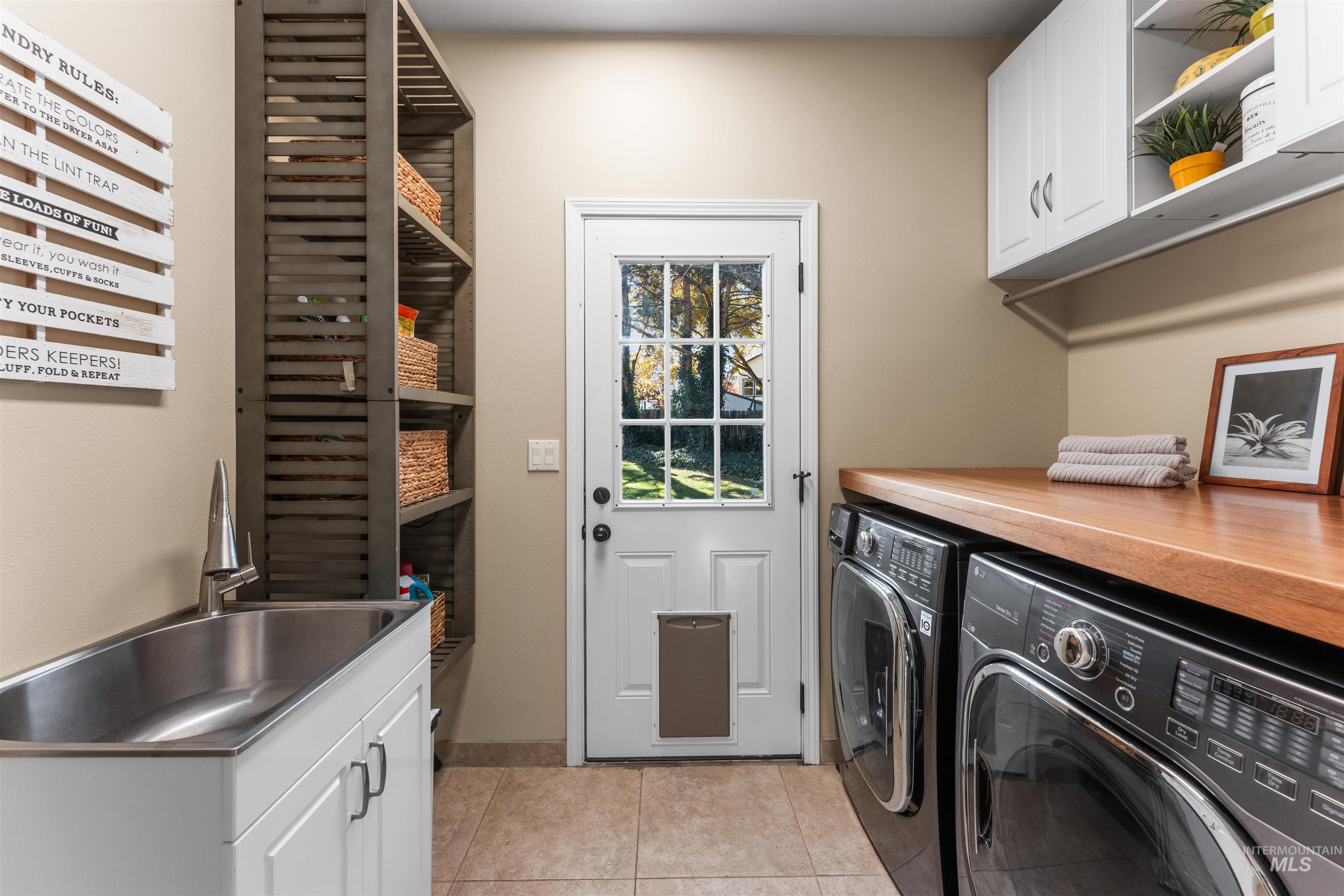 Laundry room featuring cabinet space, light tile patterned floors, and washer and dryer