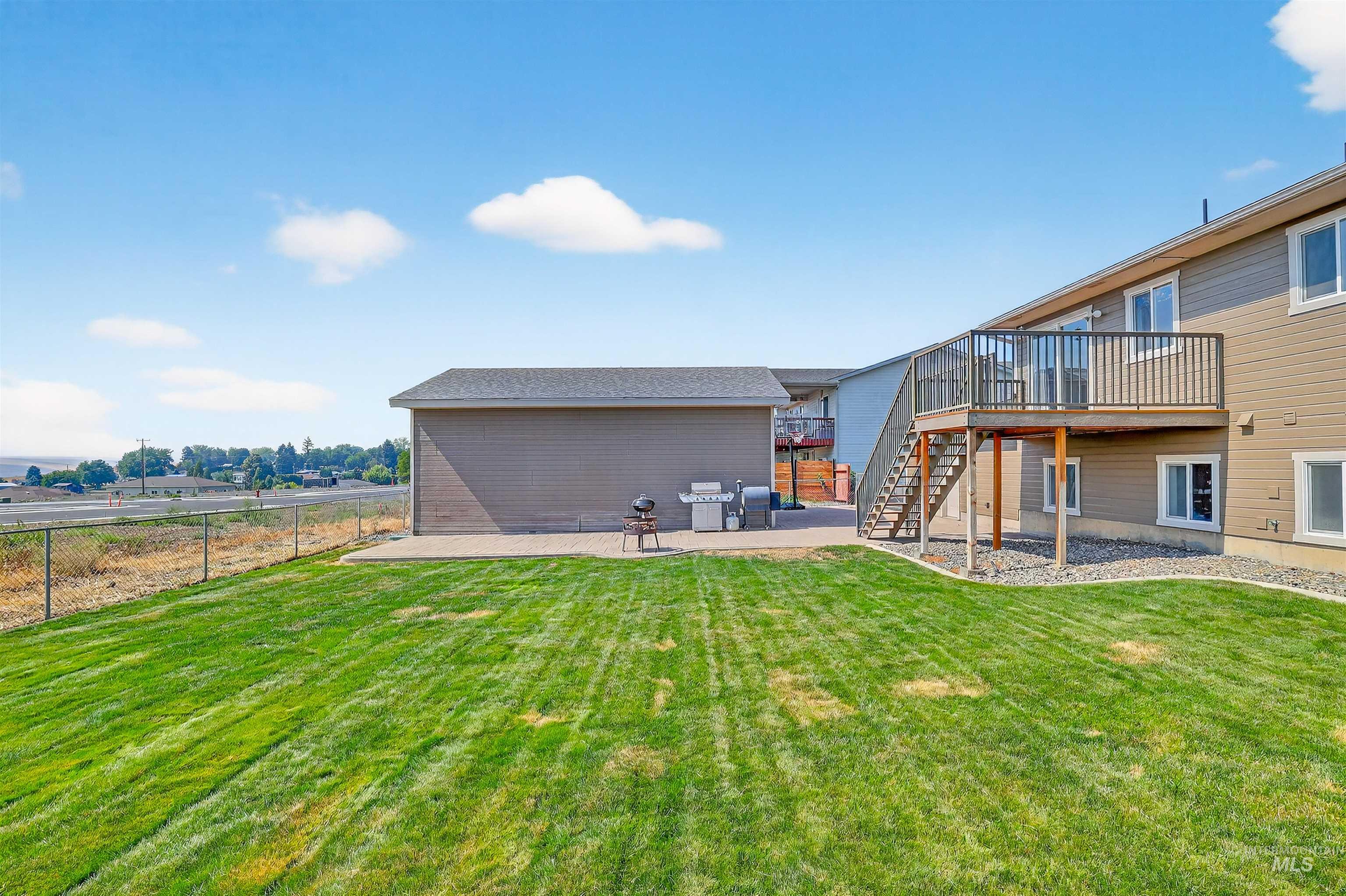 View of yard featuring a patio area, stairs, and a deck