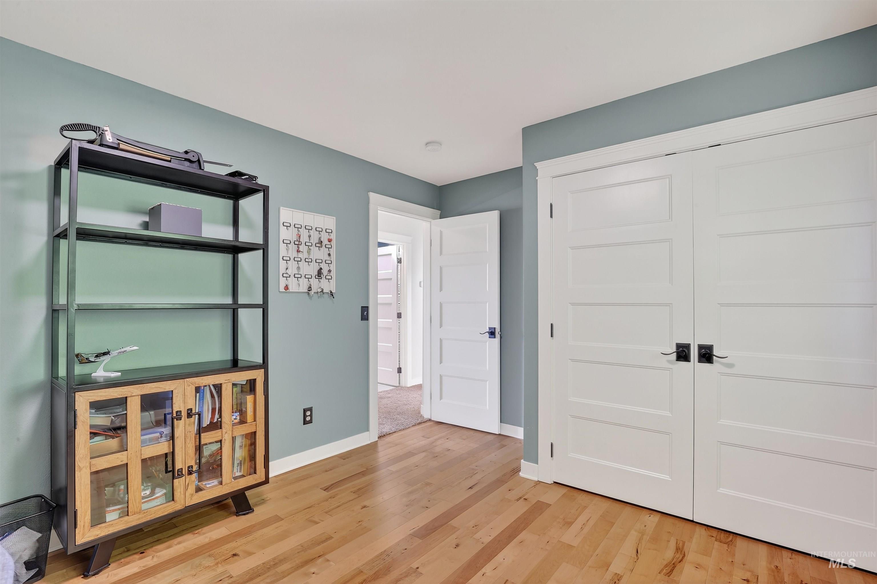 Bedroom with light wood finished floors and a closet