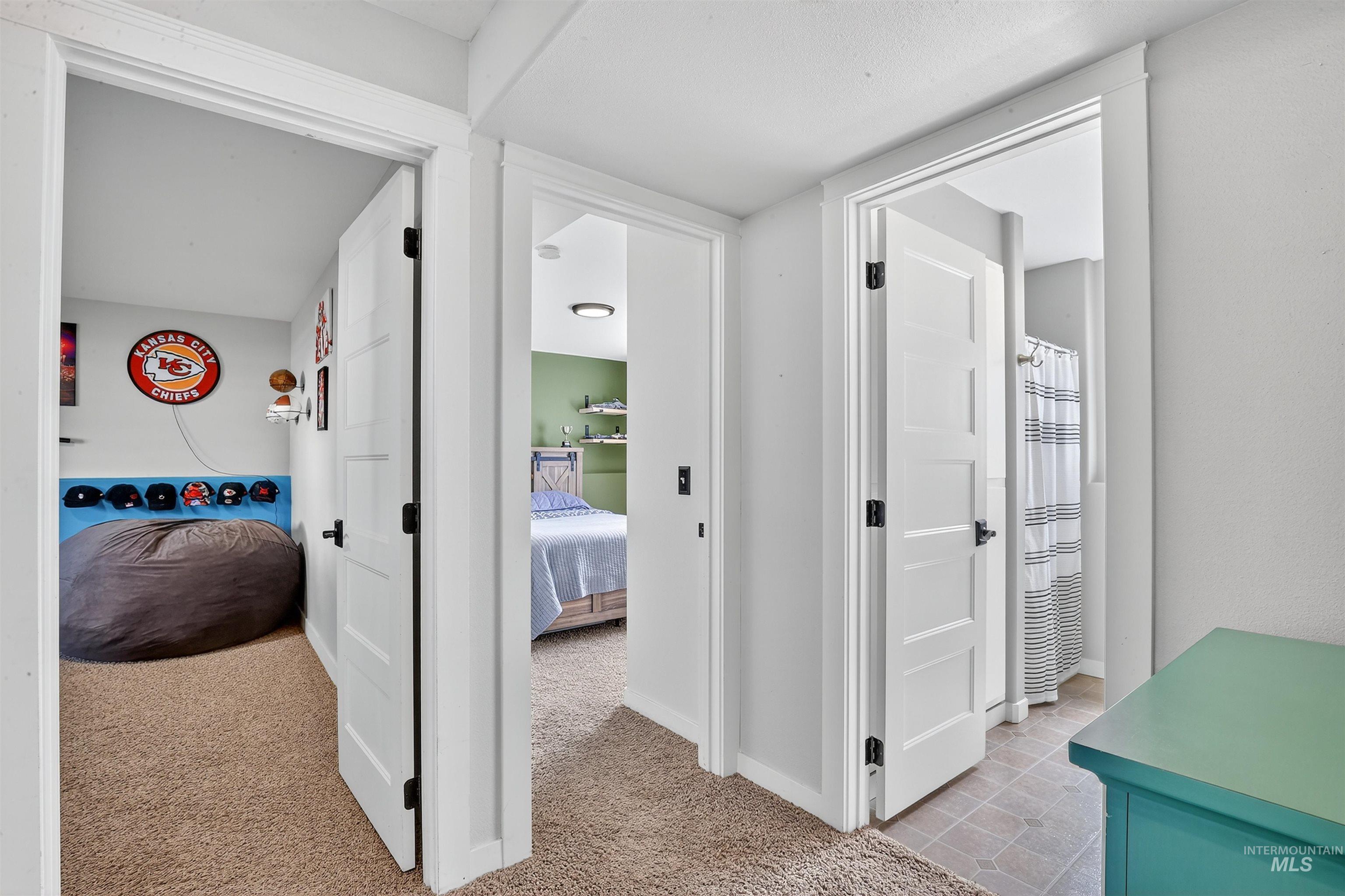 Hall with light colored carpet and baseboards