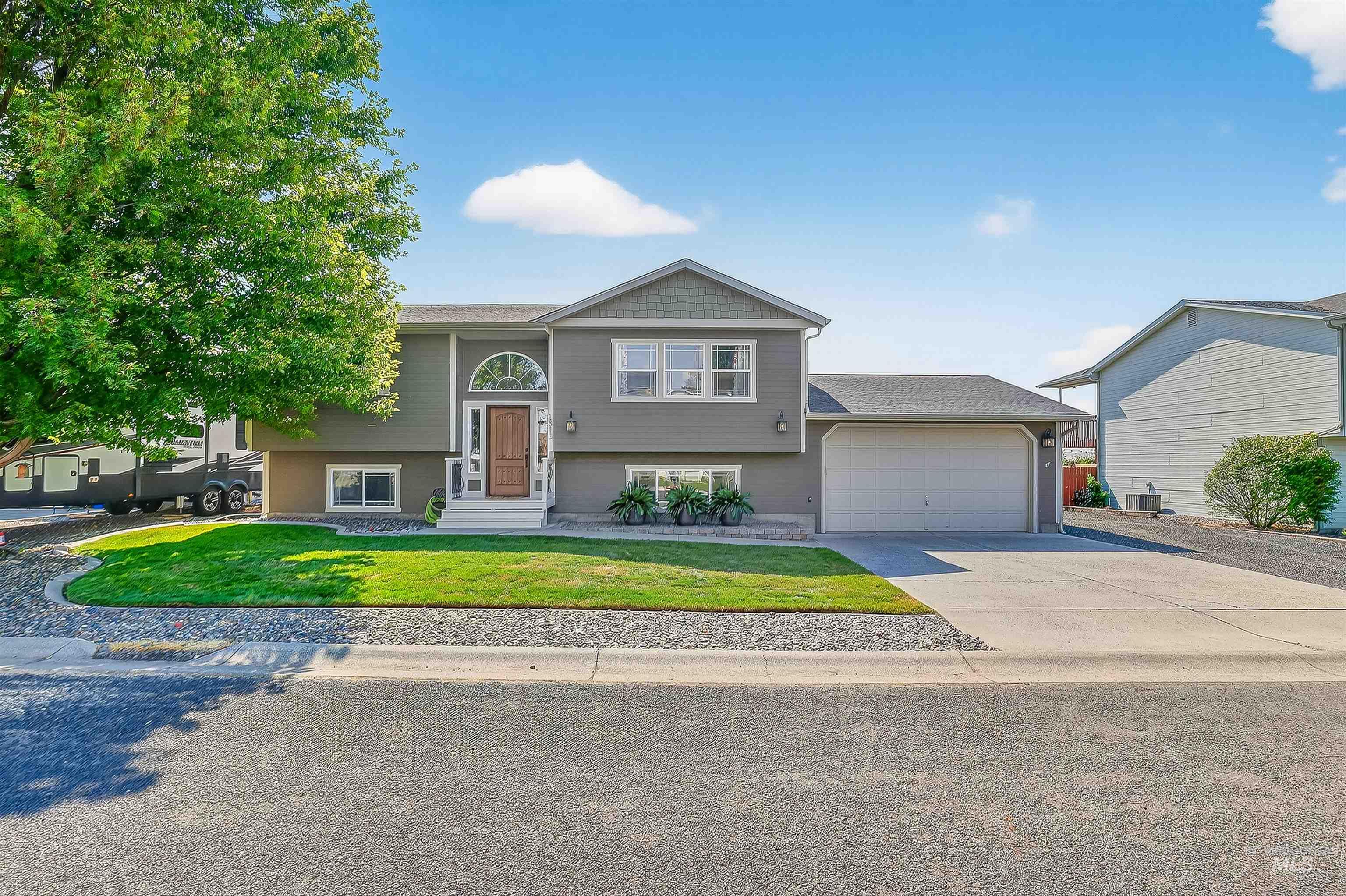 Bi-level home with a front yard, concrete driveway, and a garage