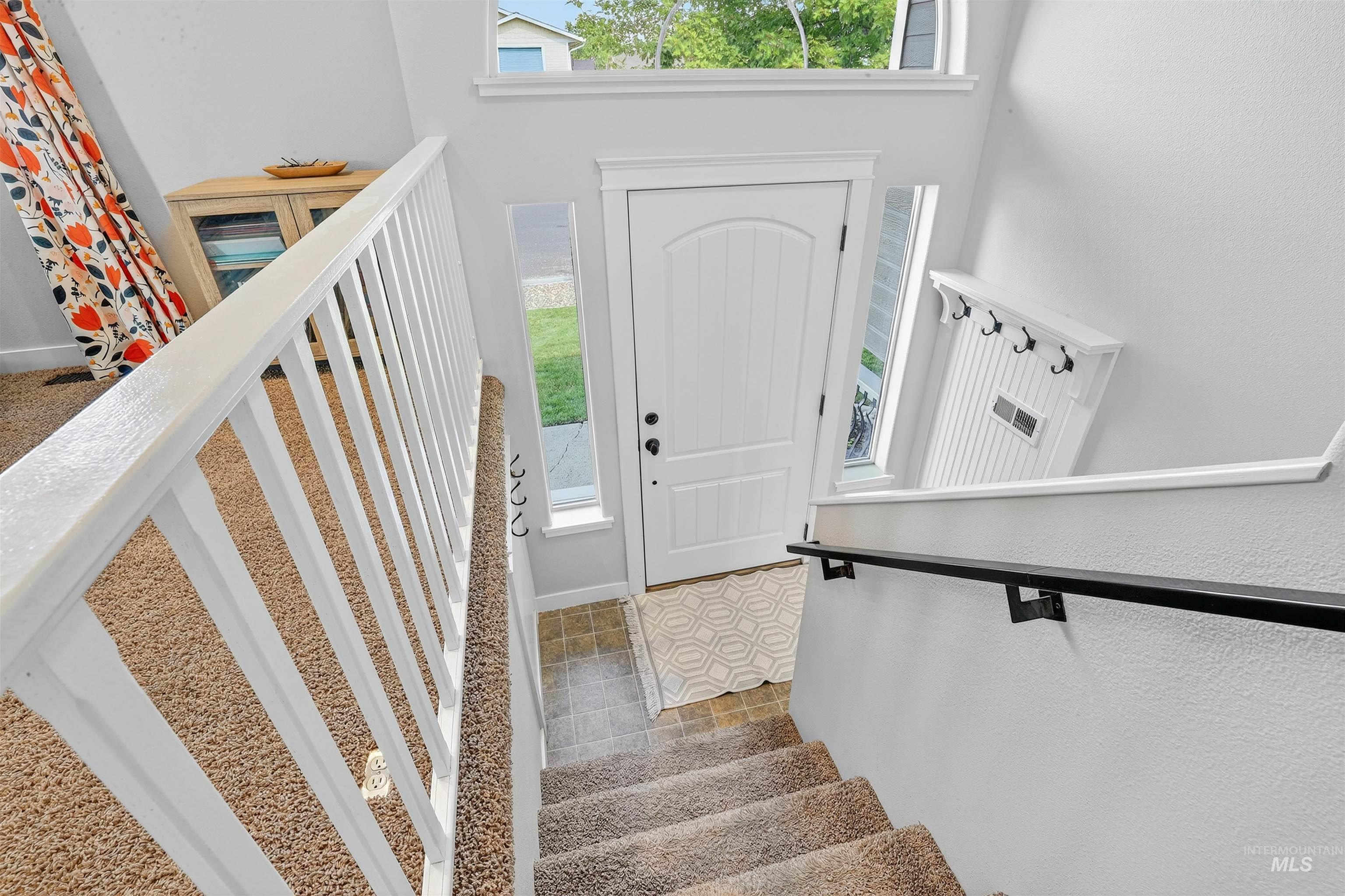 Tiled entrance foyer featuring stairway and baseboards