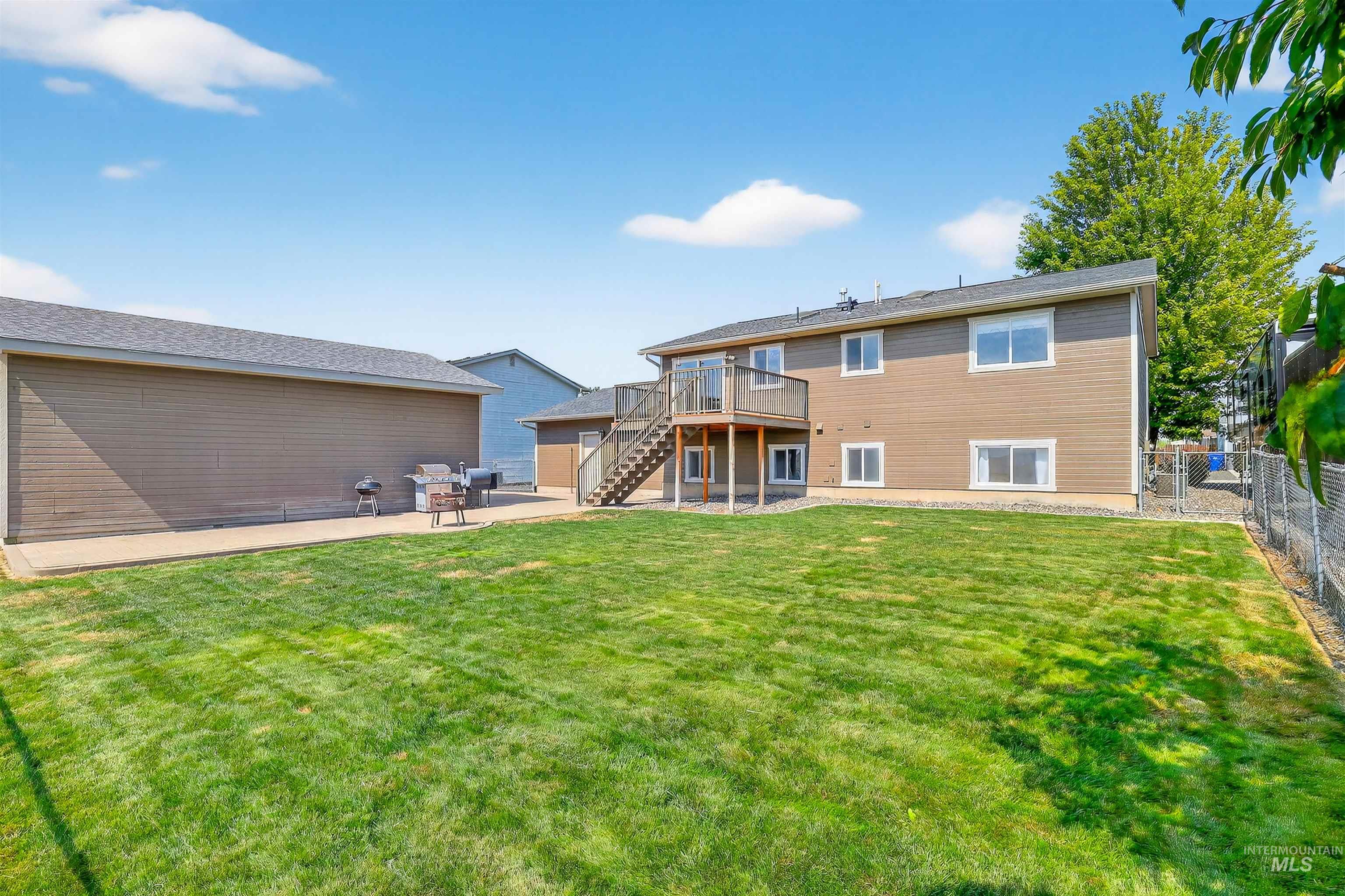 Back of property with a patio area, stairway, a deck, and a fenced backyard
