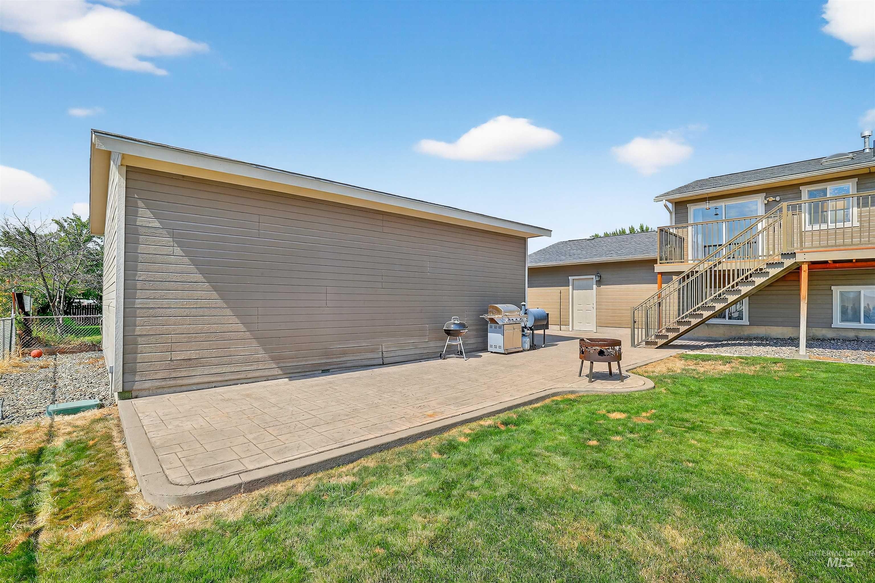 View of side of property with a patio, stairway, and a wooden deck