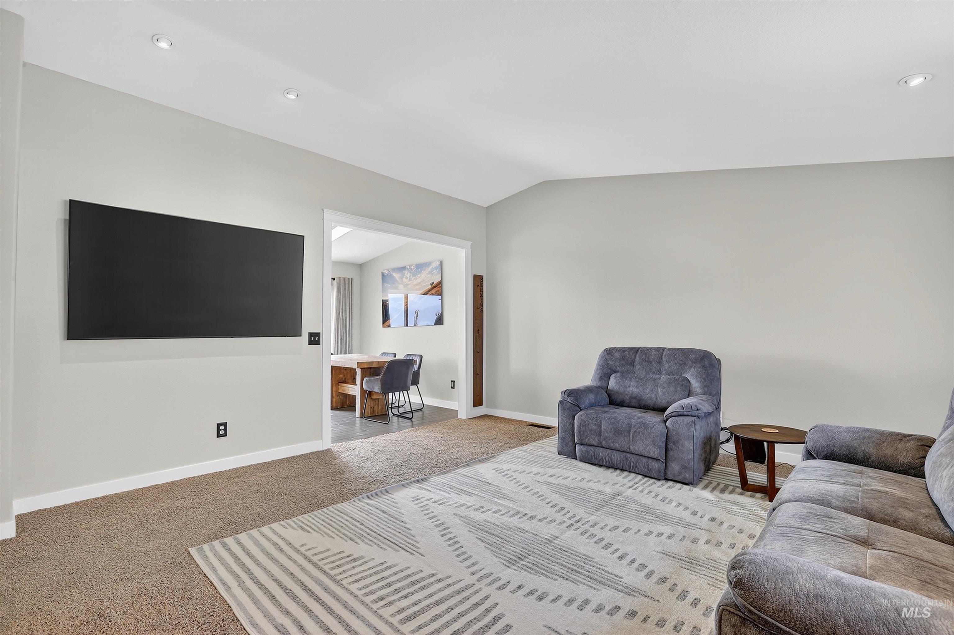 Carpeted living area featuring a desk, lofted ceiling, and recessed lighting