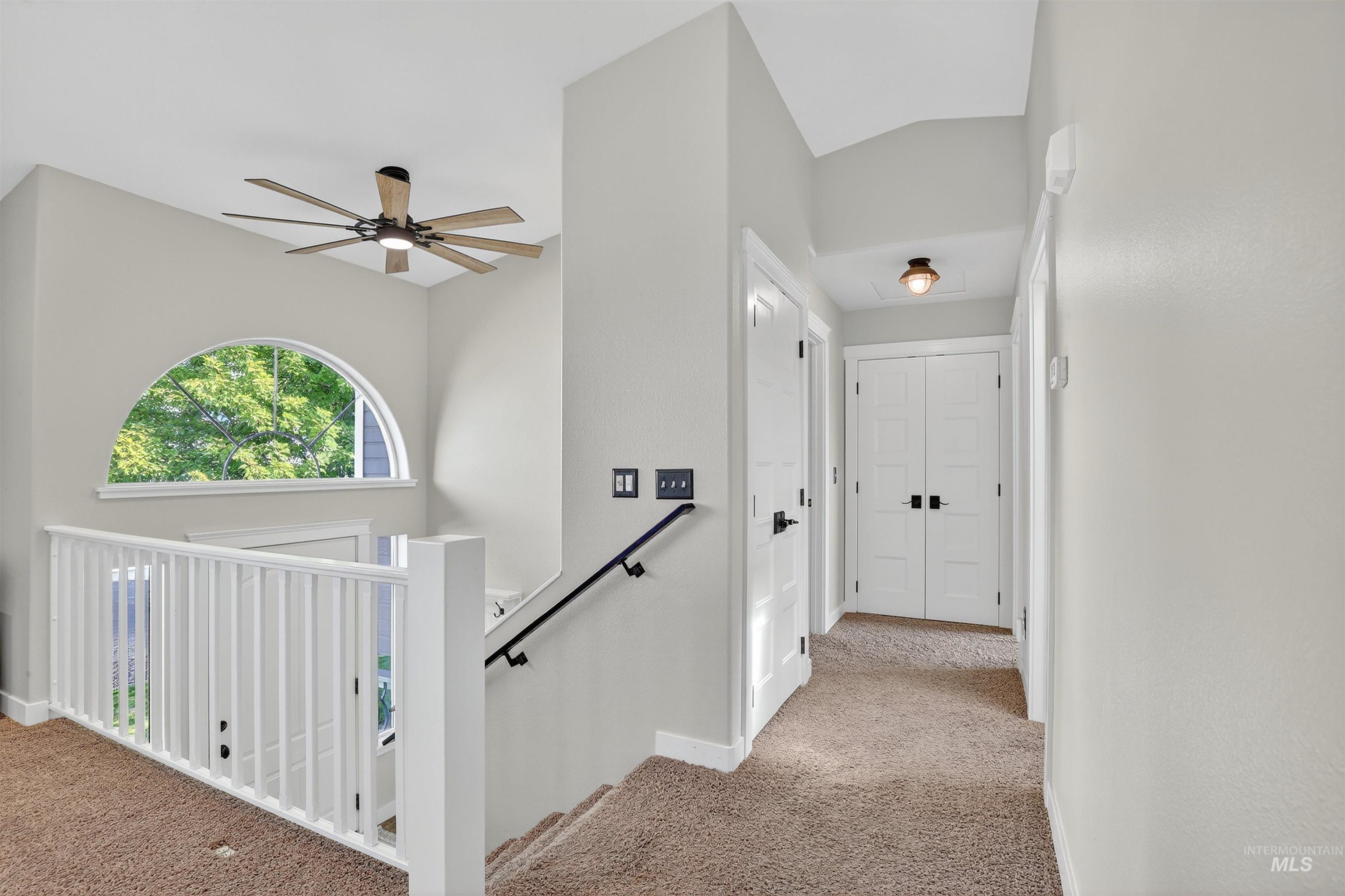 Corridor with light carpet and an upstairs landing
