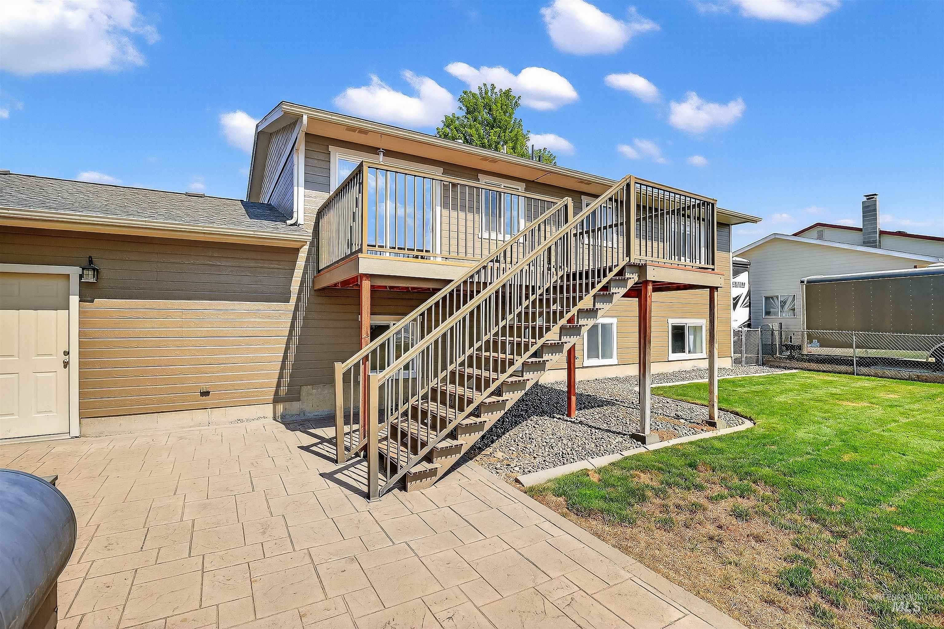 Back of property featuring stairway, a yard, a patio area, and a deck