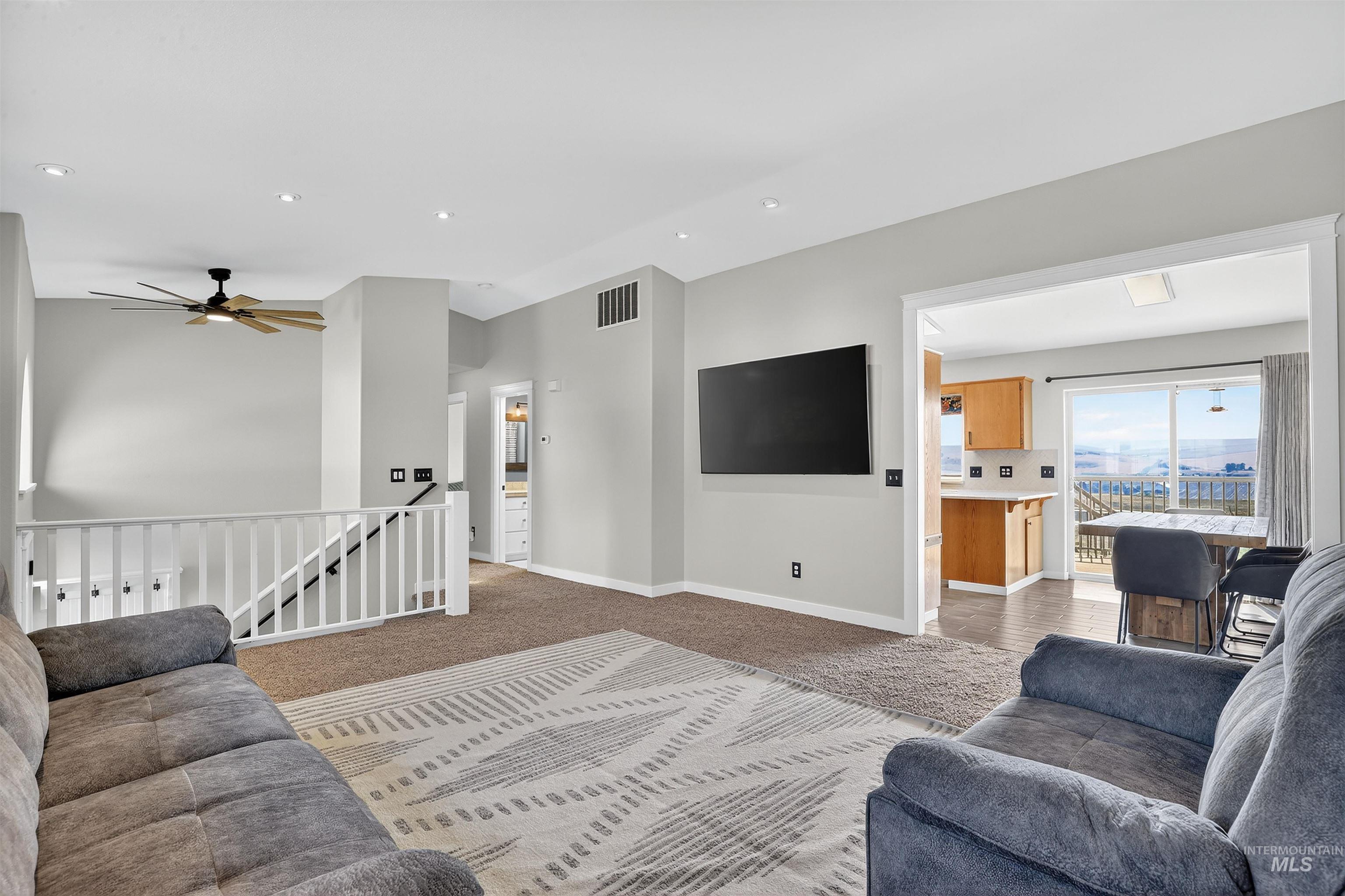 Living area with ceiling fan, carpet, and recessed lighting