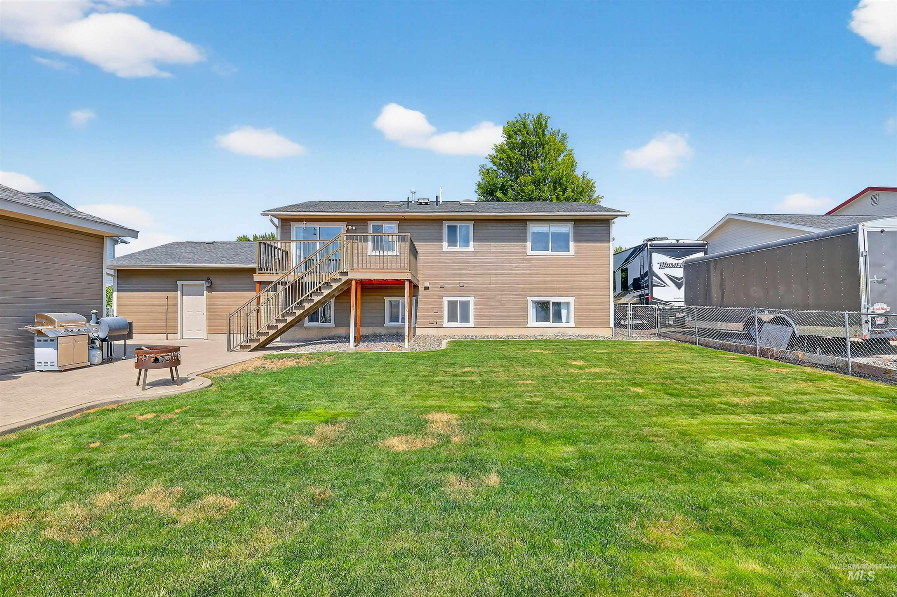 Rear view of house with a patio area, stairs, a wooden deck, and a fenced backyard