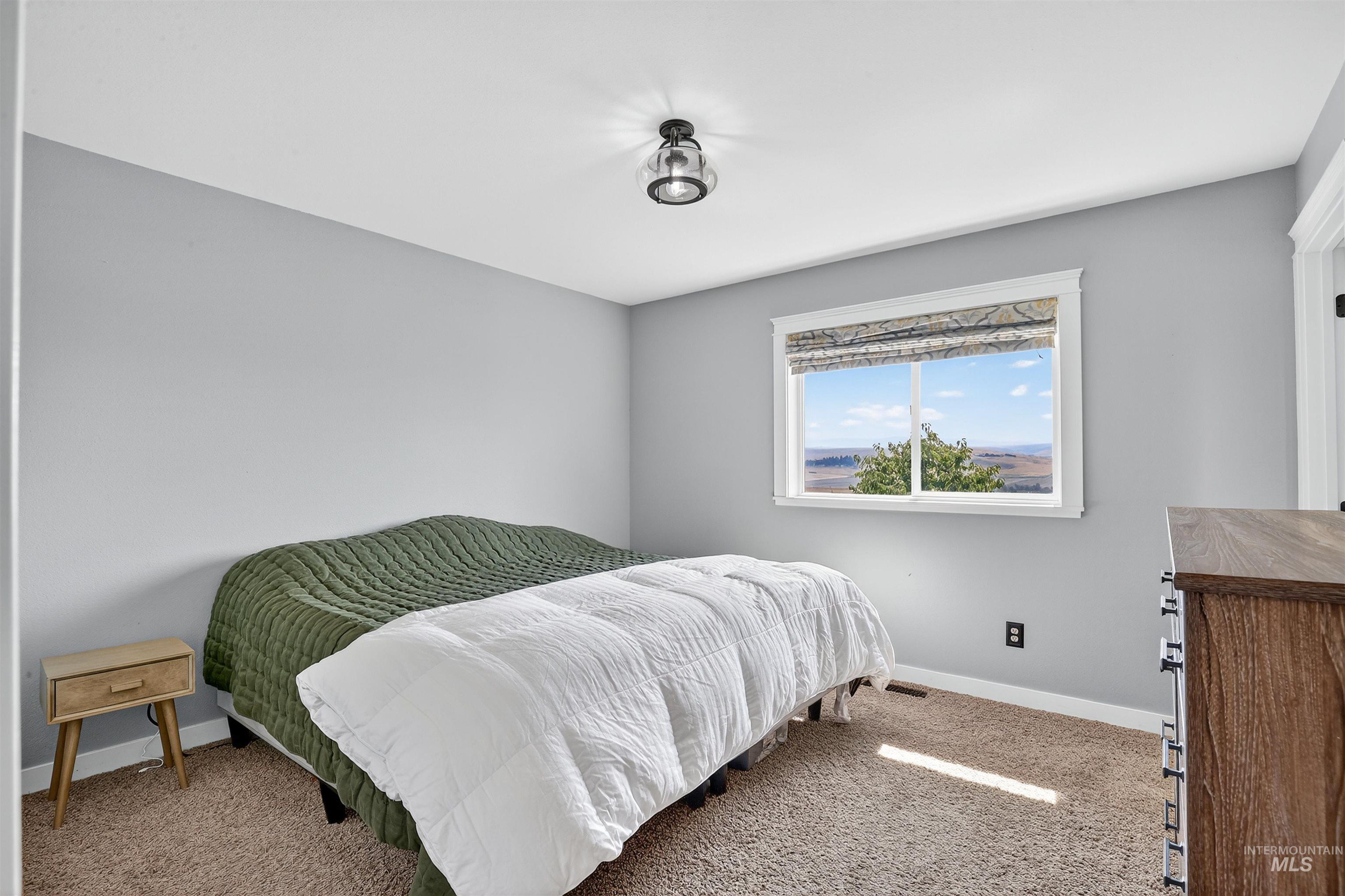 Carpeted bedroom featuring baseboards