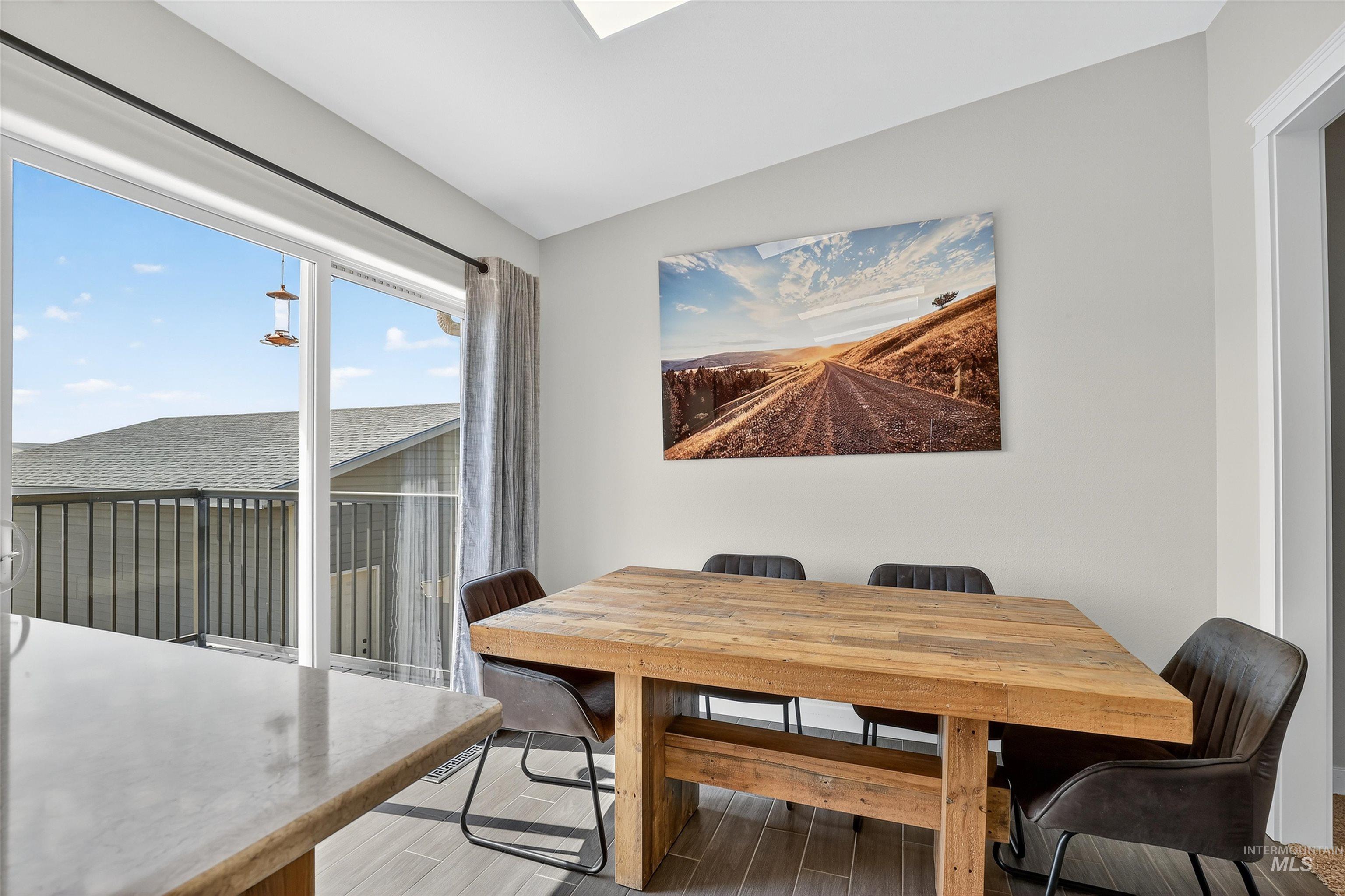 Dining area featuring light wood-style floors and lofted ceiling