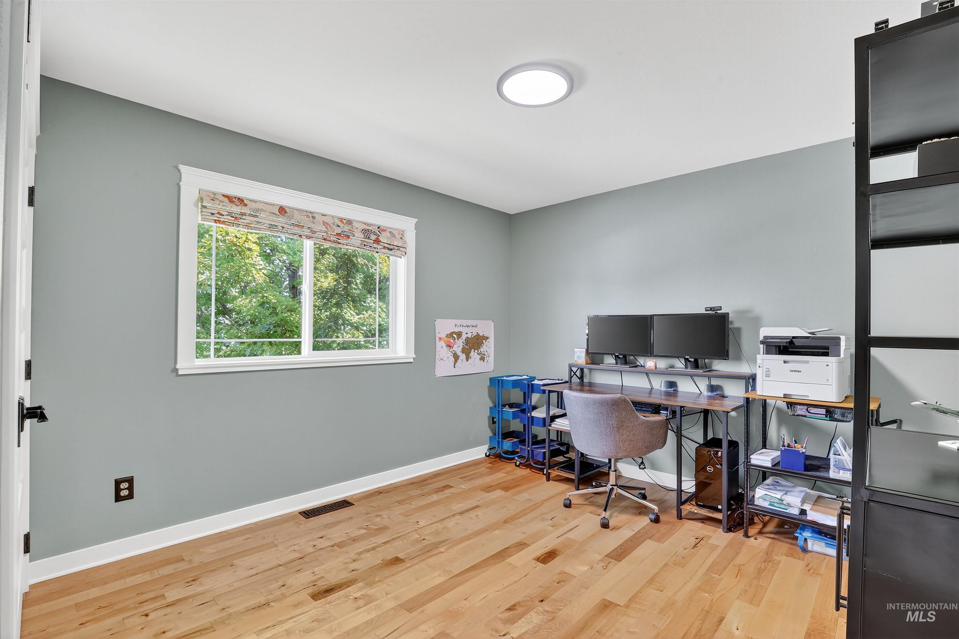 Office with light wood-style flooring and baseboards