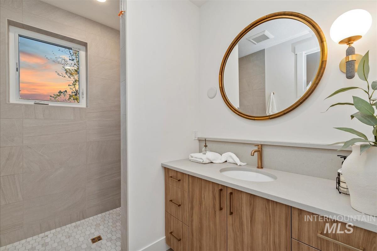 Full bathroom featuring vanity and tiled shower