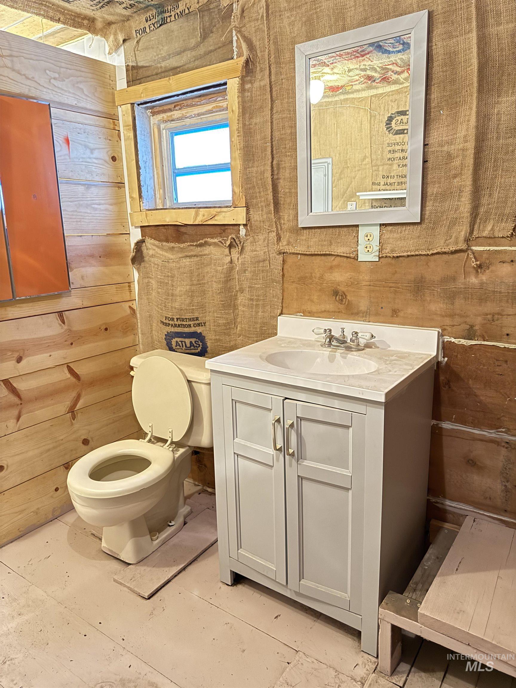 Bathroom with vanity and wood walls