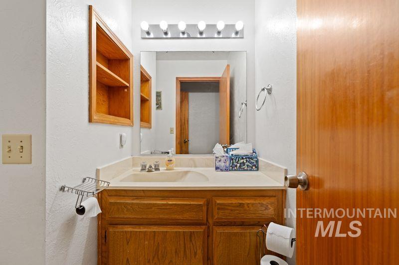 Bathroom featuring vanity and a textured wall