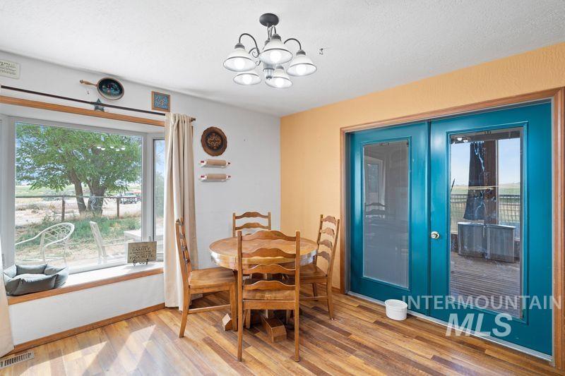 Dining space with light wood-type flooring and a chandelier
