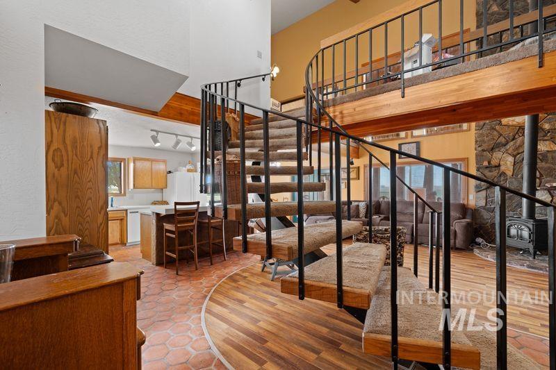 Staircase with a wood stove and wood finished floors