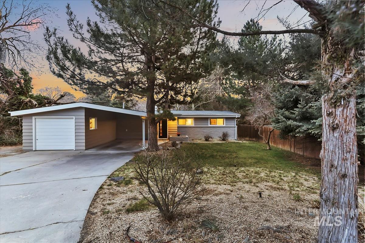 Ranch-style house with driveway, a garage, and an attached carport