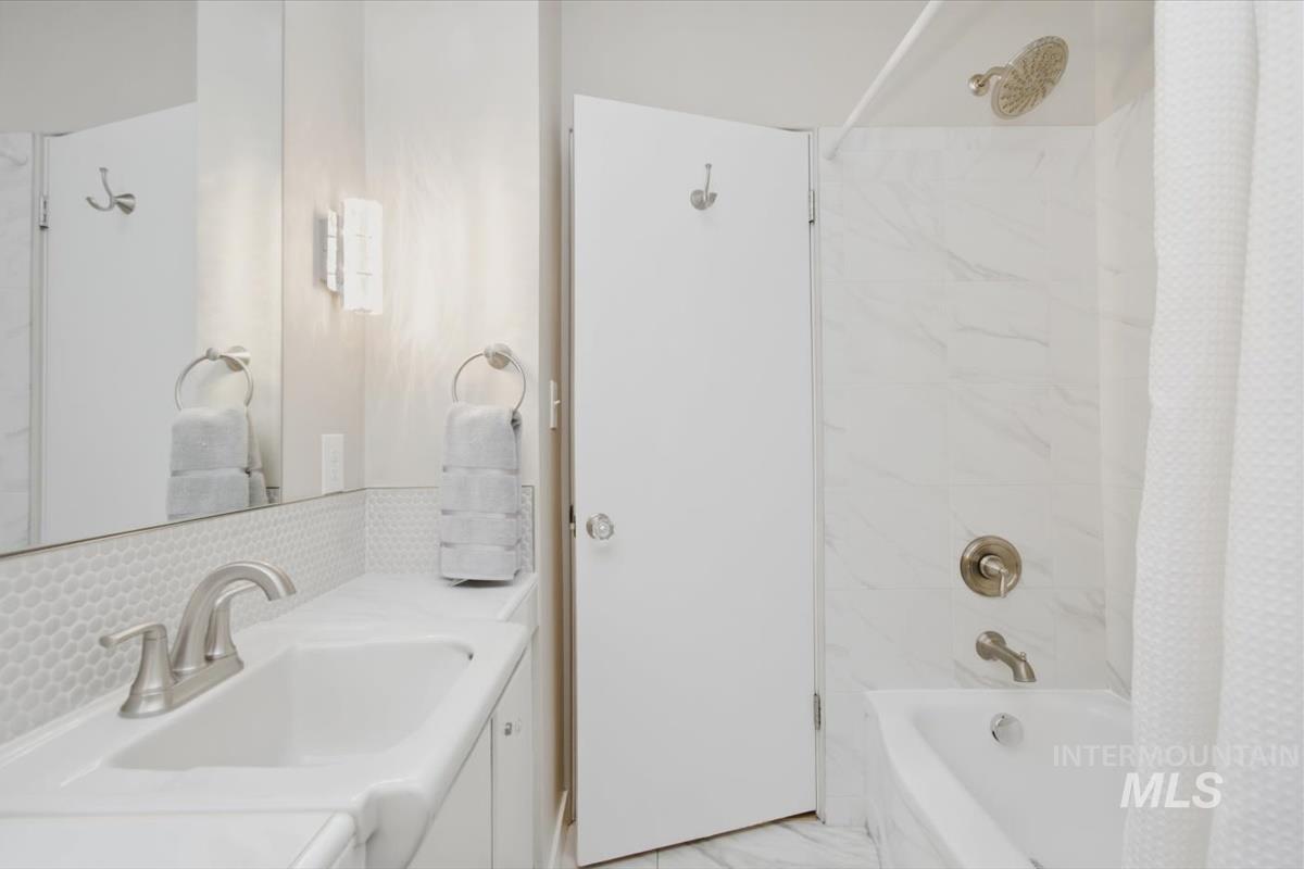 Full bathroom with shower / bathtub combination with curtain and vanity